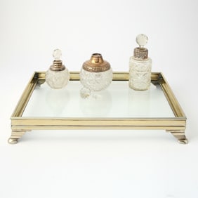 Three Silver-Mounted Cut-Glass Stoppered Perfume Bottles on a Silver-Plated Glass-Bottom Tray