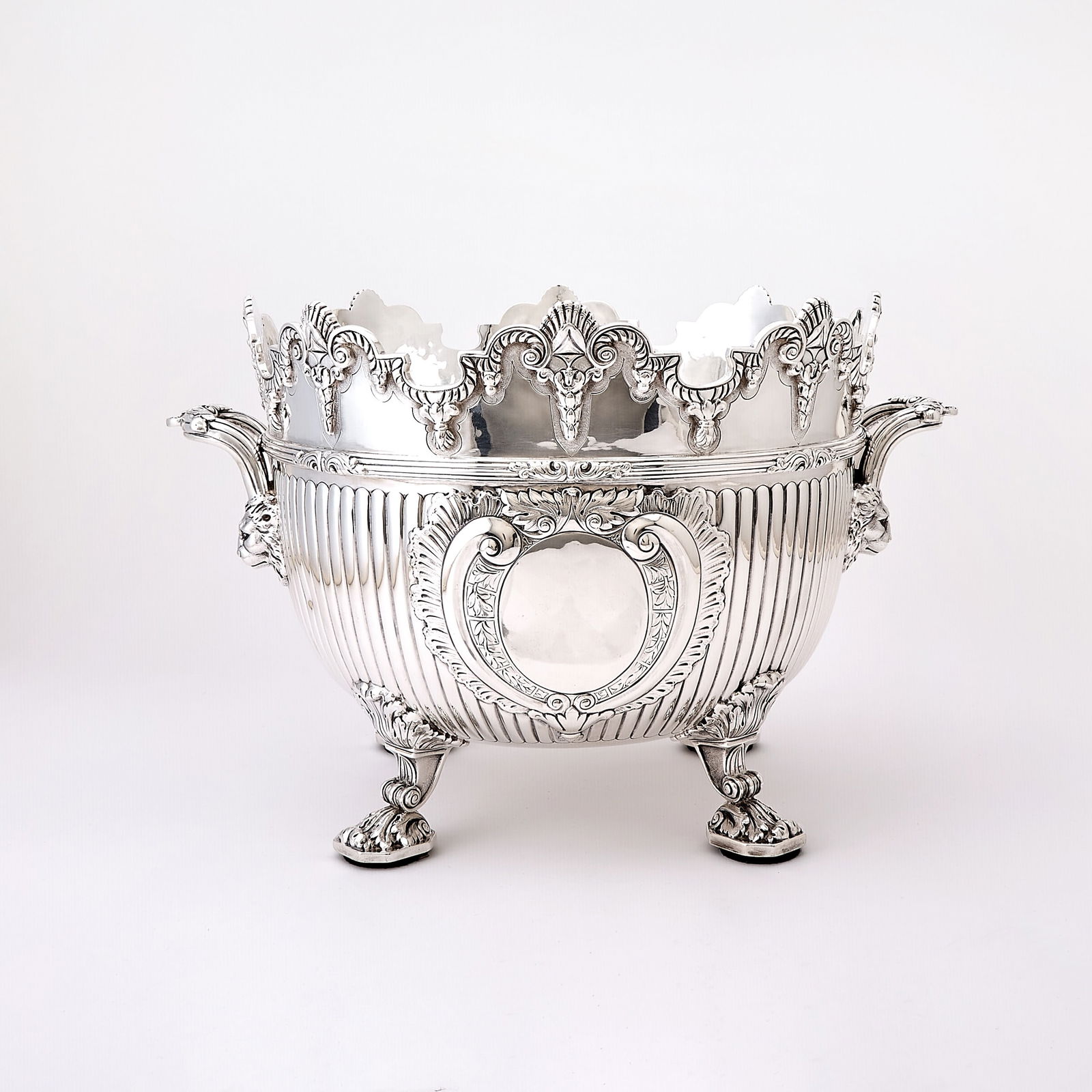 Victorian Sterling Silver Monteith Centerpiece Bowl: Charles Stuart Harris, London, 1896 In the Queen Anne style, the scalloped C-scroll gadrooned and tassel-cast rim above a reeded and leaf-cast border flanked by lion-mask and leaf-cast reeded loop han