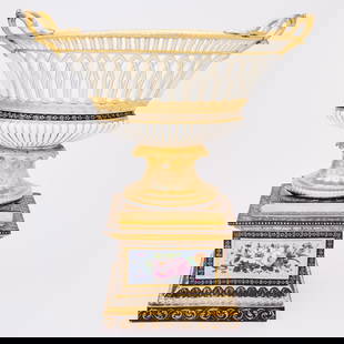 Paris Porcelain Two-Handled Basket Centerpiece: Circa 1850 The reticulated oval basket applied with twin handles, with a gadrooned foot supported on a stepped square base painted with a floral reserve framed in a foliate gilt border reserved on a b