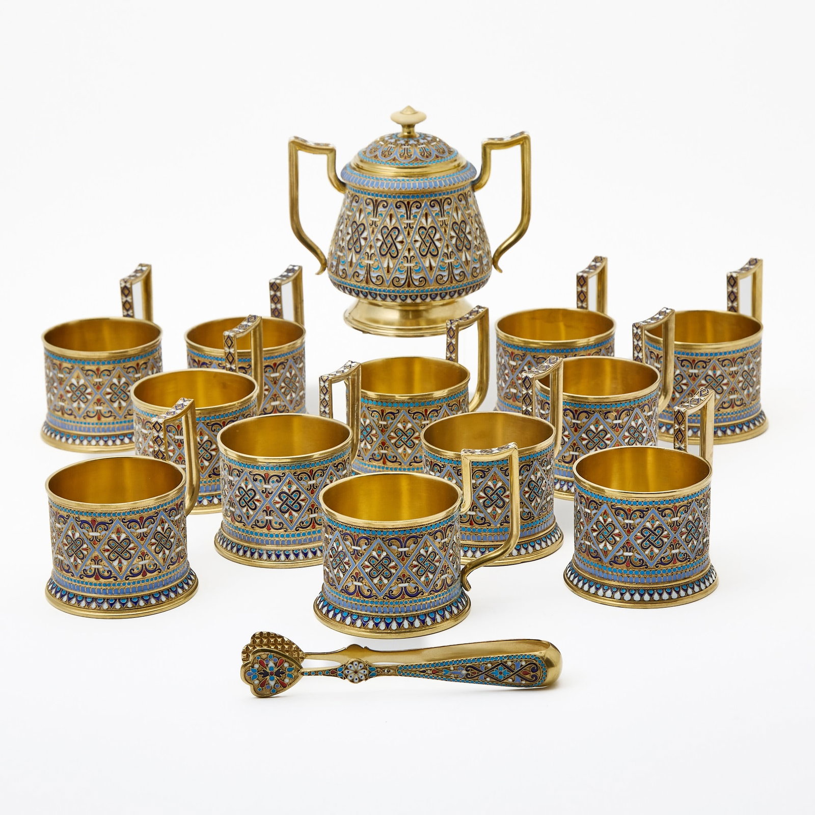 Russian Silver-Gilt and Cloisonné Enamel Partial Tea Service: Gustav Klingert, Moscow, 1892 Comprising twelve tea glass holders, a covered sugar bowl and a sugar tongs; the tea glass holders each cylindrical, on a domed circular foot, with an angular handle; the