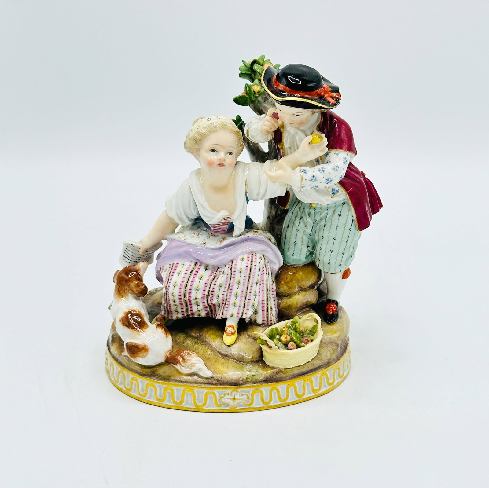 Meissen Porcelain Figural Group: Depicting a seated girl and boy with a dog. Marked on underside. Height 6 inches.