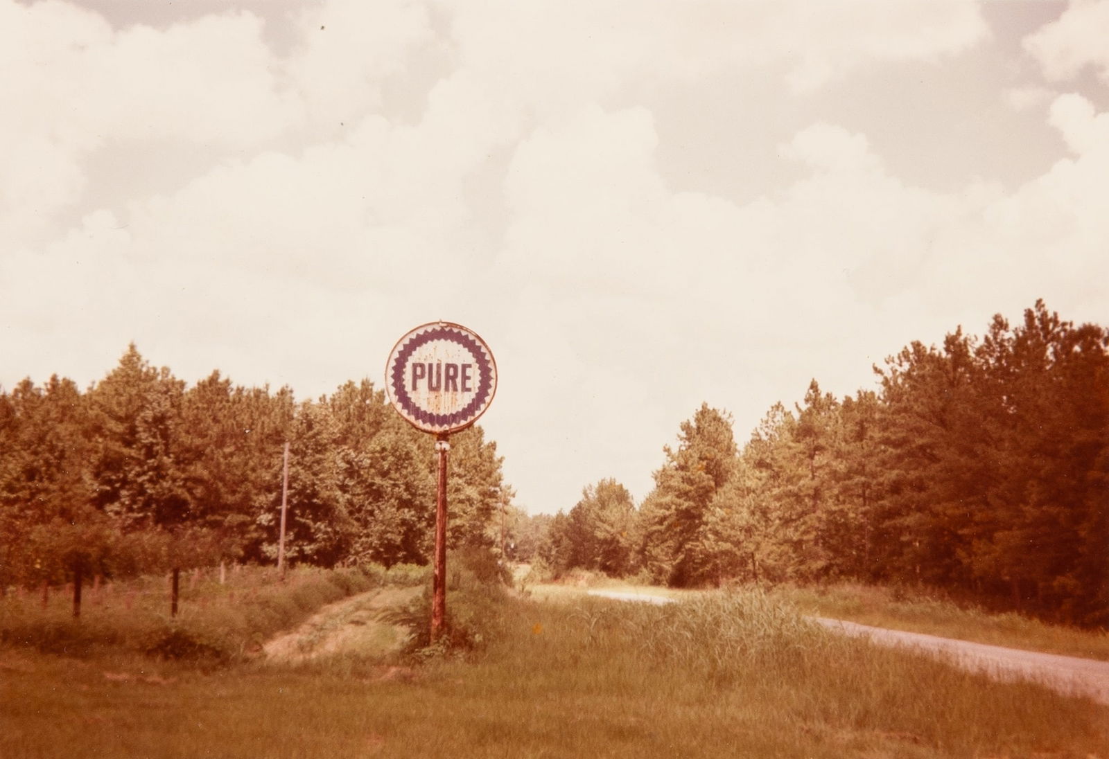 William Christenberry, Pure Oil Sign in Landscape, Near Marion, Alabama, 1977: CHRISTENBERRY, WILLIAM (1936-2016) Pure Oil Sign in Landscape, Near Marion, Alabama, 1977, likely printed 1980. Kodak type "C" print, 3 3/8 x 5 inches (85 x 123 mm) on larger sheet, signed in pencil v