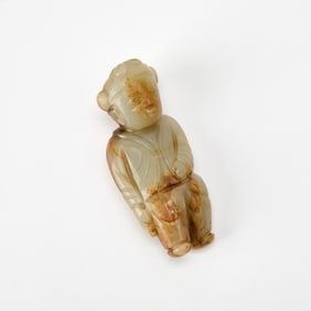 A Chinese Carved Celadon and Russet Jade Figure of a Boy Ming Dynasty