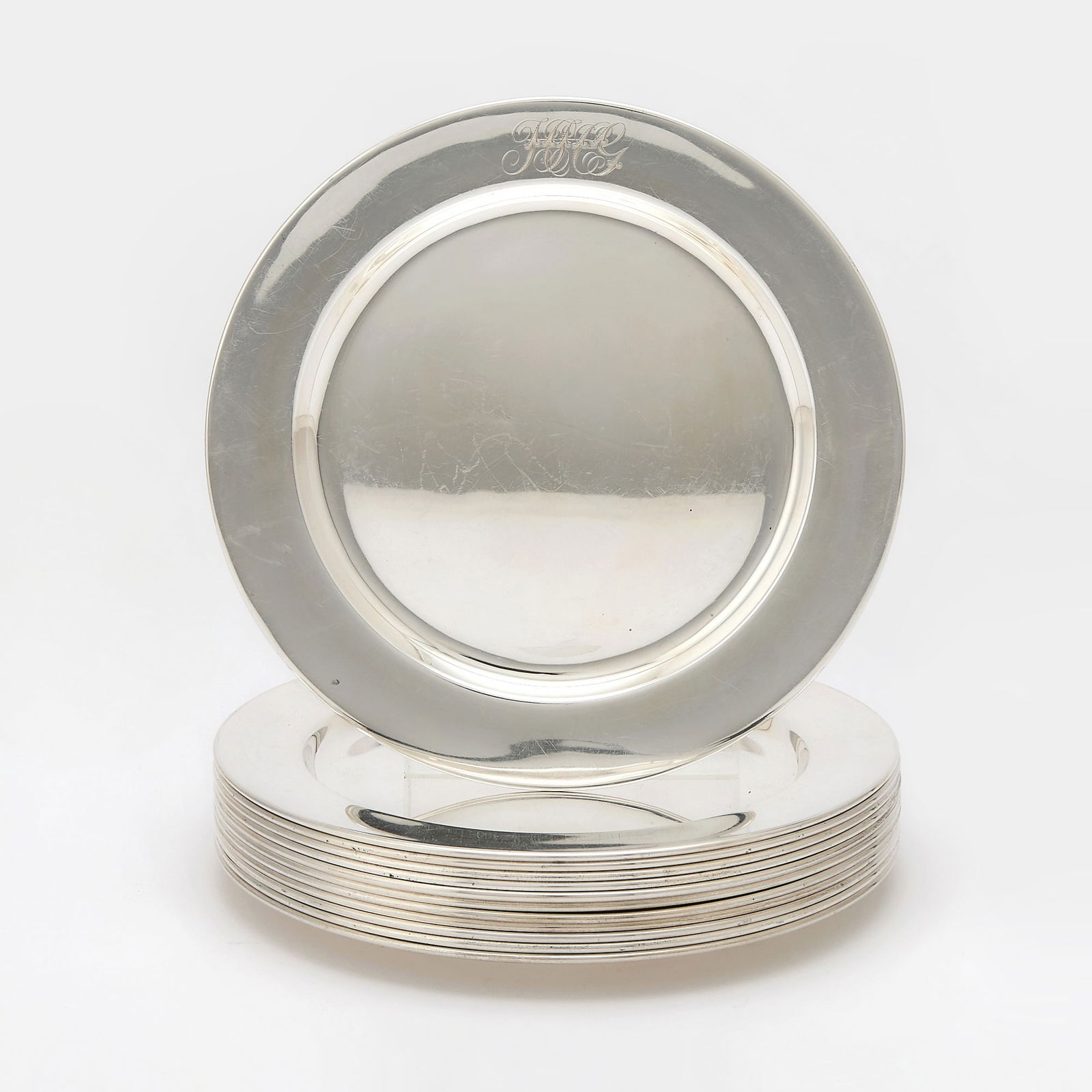 Set of Twelve Reed & Barton Sterling Silver Dinner Plates: First half 20th century Each circular with wide border. Diameter 10 1/4 inches, total approximately 213 ounces. Generally good condition overall with light surface marking and wear as expected from c