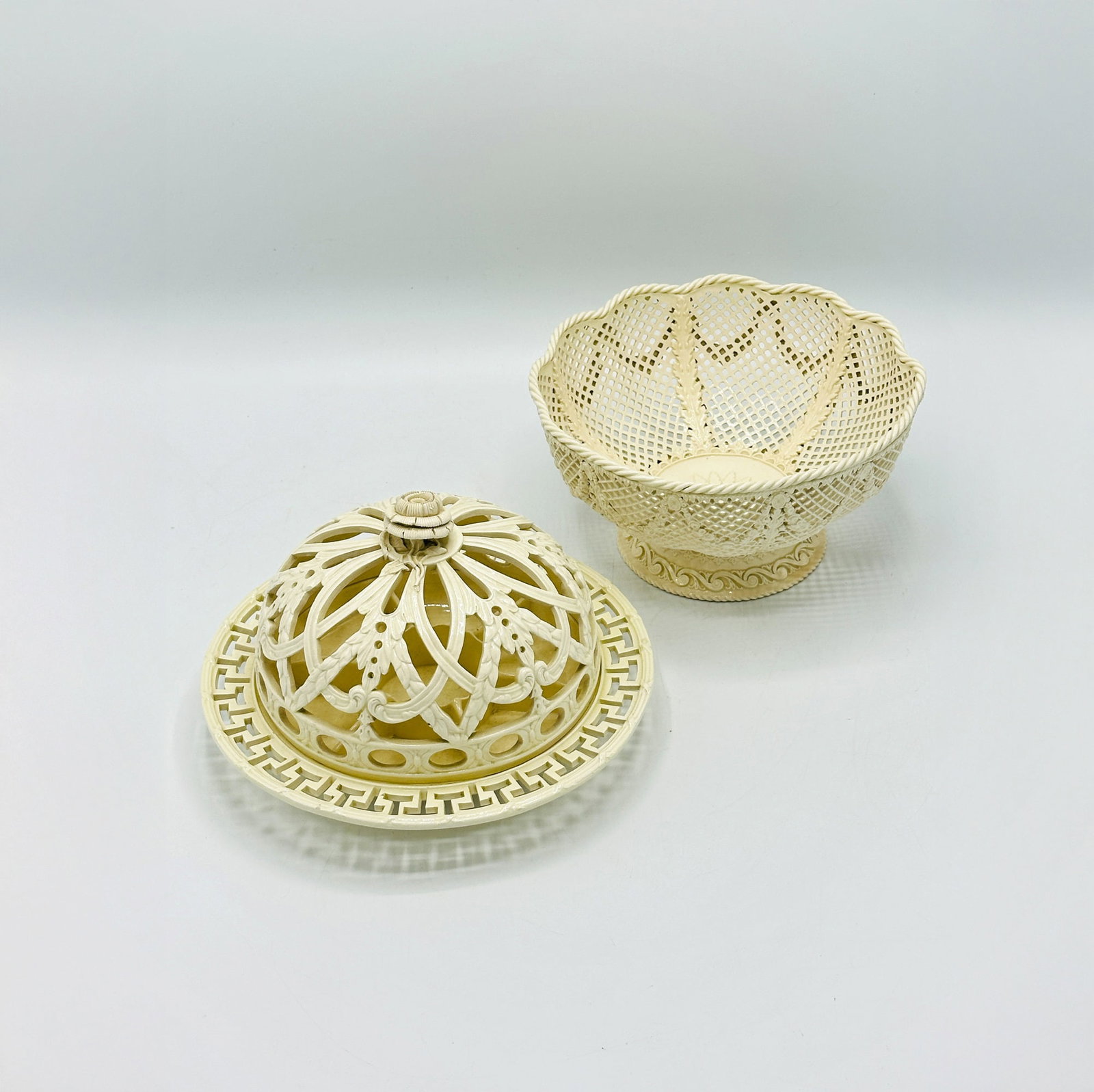 English Creamware Domed Citrus Bowl and a Lattice Fruit Bowl: 18th and late 19th century, the lattice fruit bowl marked "WEDGWOOD." Citrus bowl diameter 8 1/2 inches, lattice bowl diameter inches. Please note: This lot will be on view in Boston.