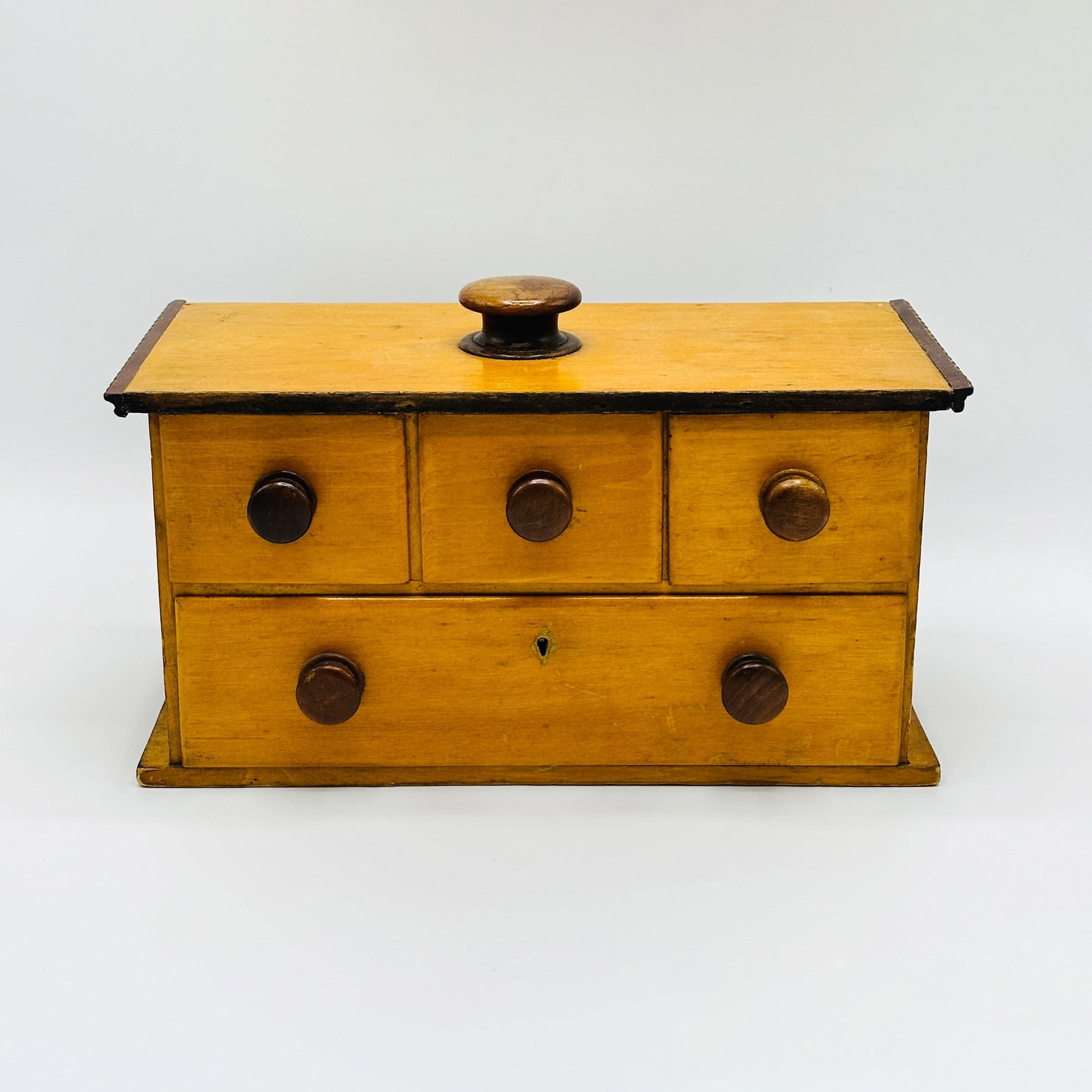 Yellow-painted Four-Drawer Case: New England, mid 18th century The top with turned wood pull and ripple-molded edge, above three nail-constructed thumbmolded short drawers and single long drawer, each with similar turned wood pulls. 