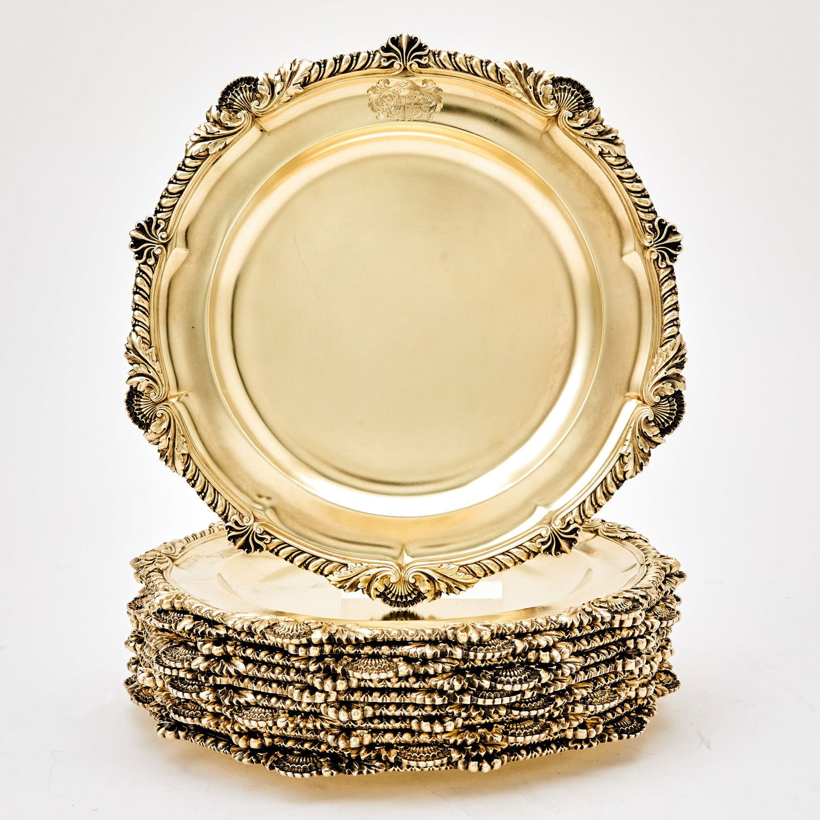 Set of Eleven George IV Sterling Silver Gilt Dinner Plates: Benjamin Smith, London, 1824 Each shaped circular with shell and gadrooned rim. Diameter 10 1/4 inches (26 cm), total approximately 244 ounces. Good condition overall with light surface marking from