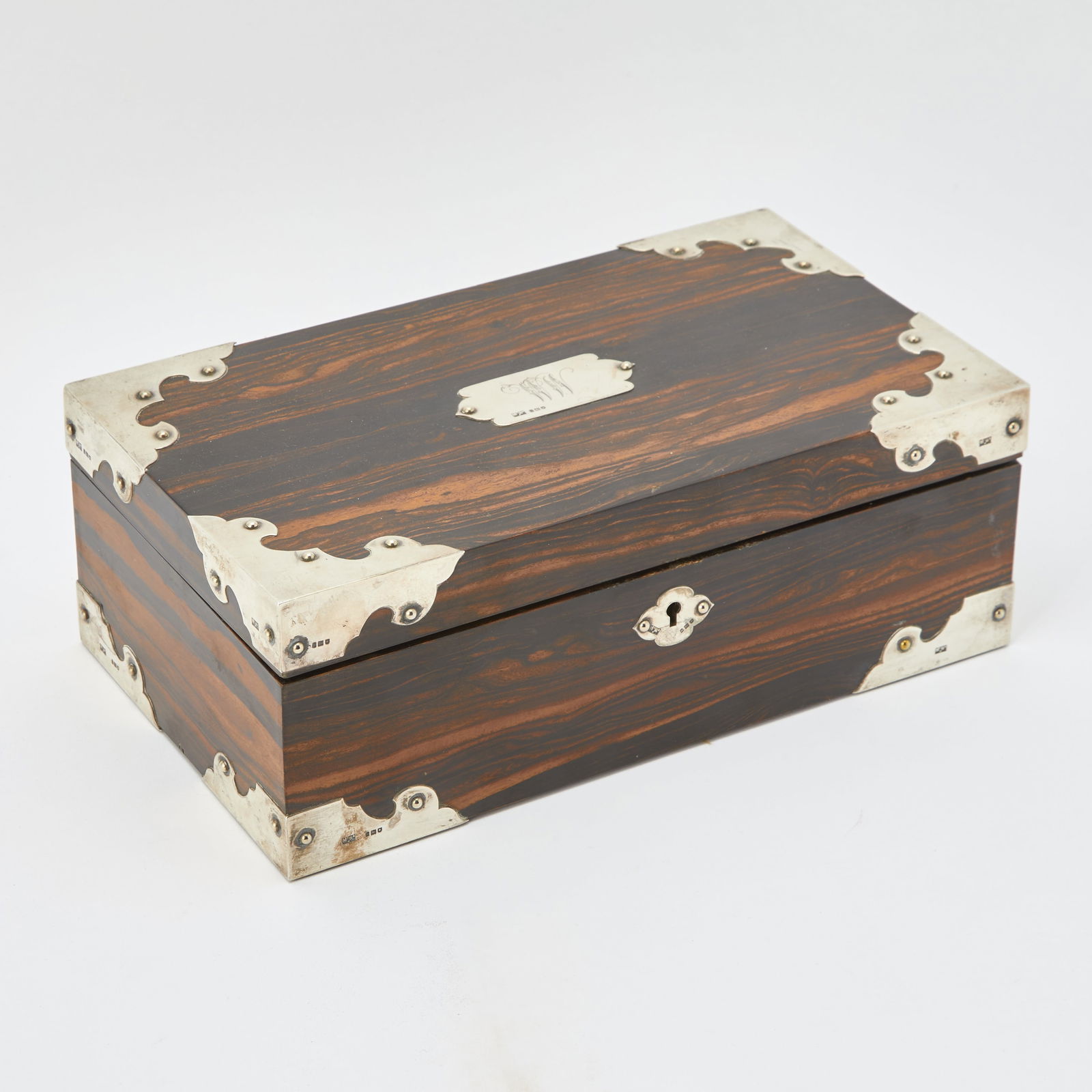 Edward VII Sterling Silver Mounted Rosewood Cigar Box: Mappin & Webb, London, 1903 Of rectangular form, the rich grained case fitted with silver mounts to the corners and edges, each in shaped foliate outline, and a engraved cartouche to the lid. The