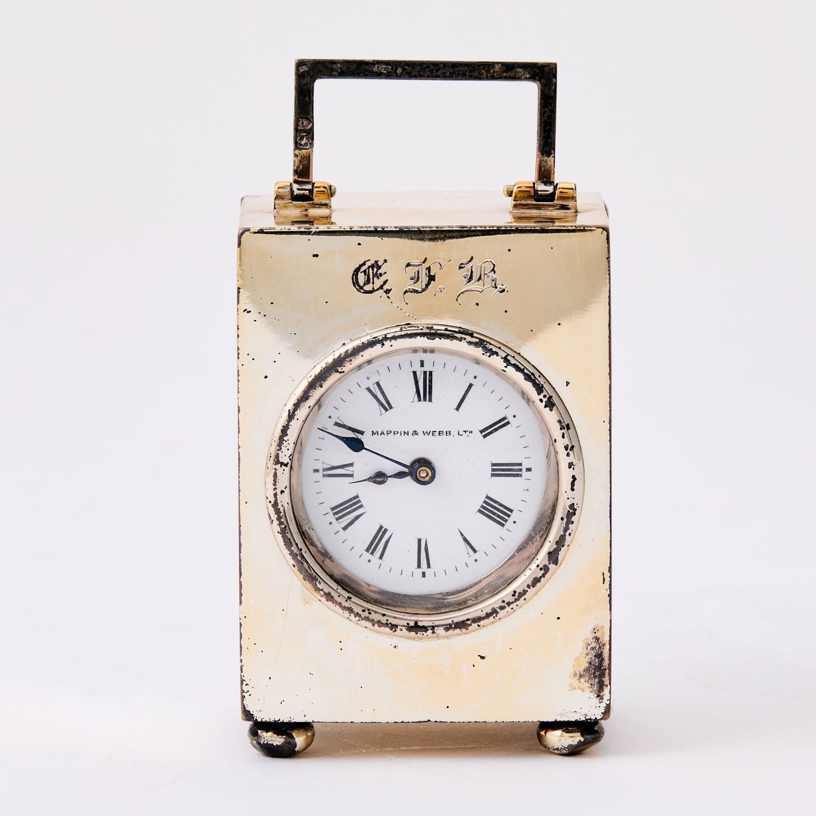Edward VII Sterling Silver Miniature Carriage Clock: Mappin & Webb, London, 1908 In a fitted case. Height over handle 3 1/2 inches (9 cm). Some scuffing to case and dent to one corner of back panel; clearly hallmarked; body engraved "GFB" Case gen