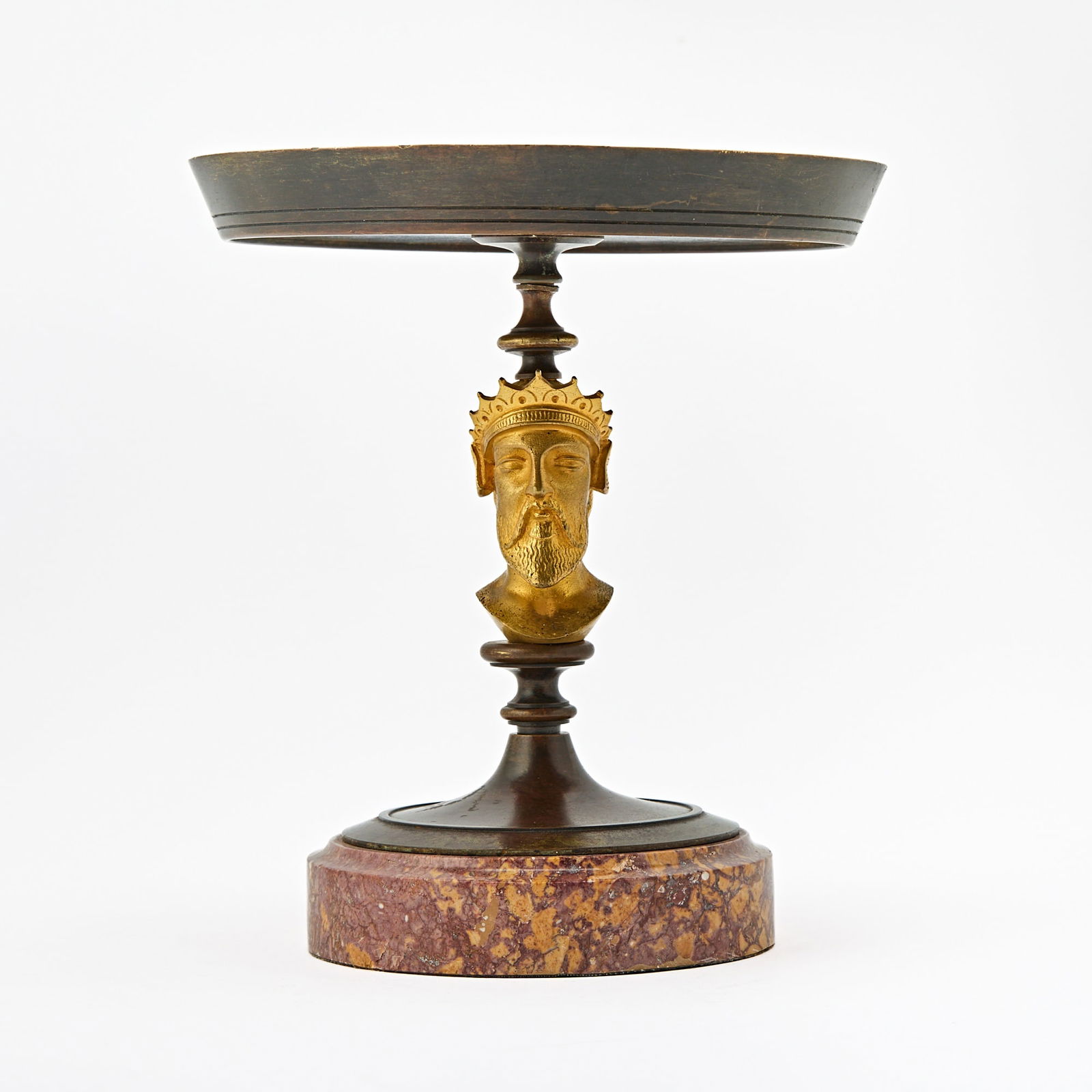 French Grand Tour Gilt and Patinated Bronze Tazza: Circa 1860 The shallow circular bronze dish on a pedestal stem finely cast with a crowned bearded male bust, and resting on a circular pink and ochre marble base. Height 8 1/2 inches (21.5 cm), diamet