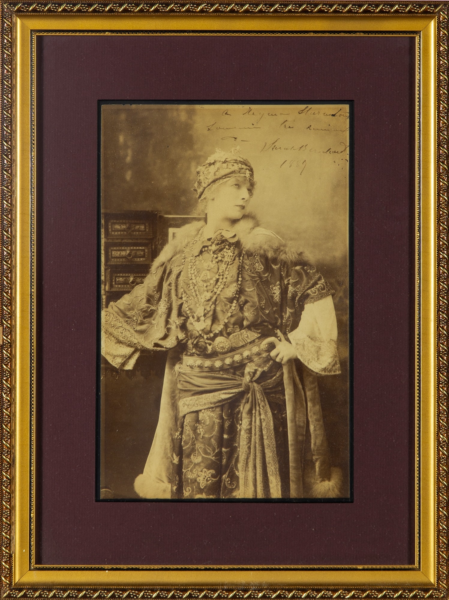 A large format inscribed photograph of Sarah Bernhardt: SARAH BERNHARDT Large inscribed photographs. An albumen print depicting Sarah Bernardt in character, inscribed in the image and dated 1887. 11 1/4 x 7 inches. Framed. Some minor visible toning to extr