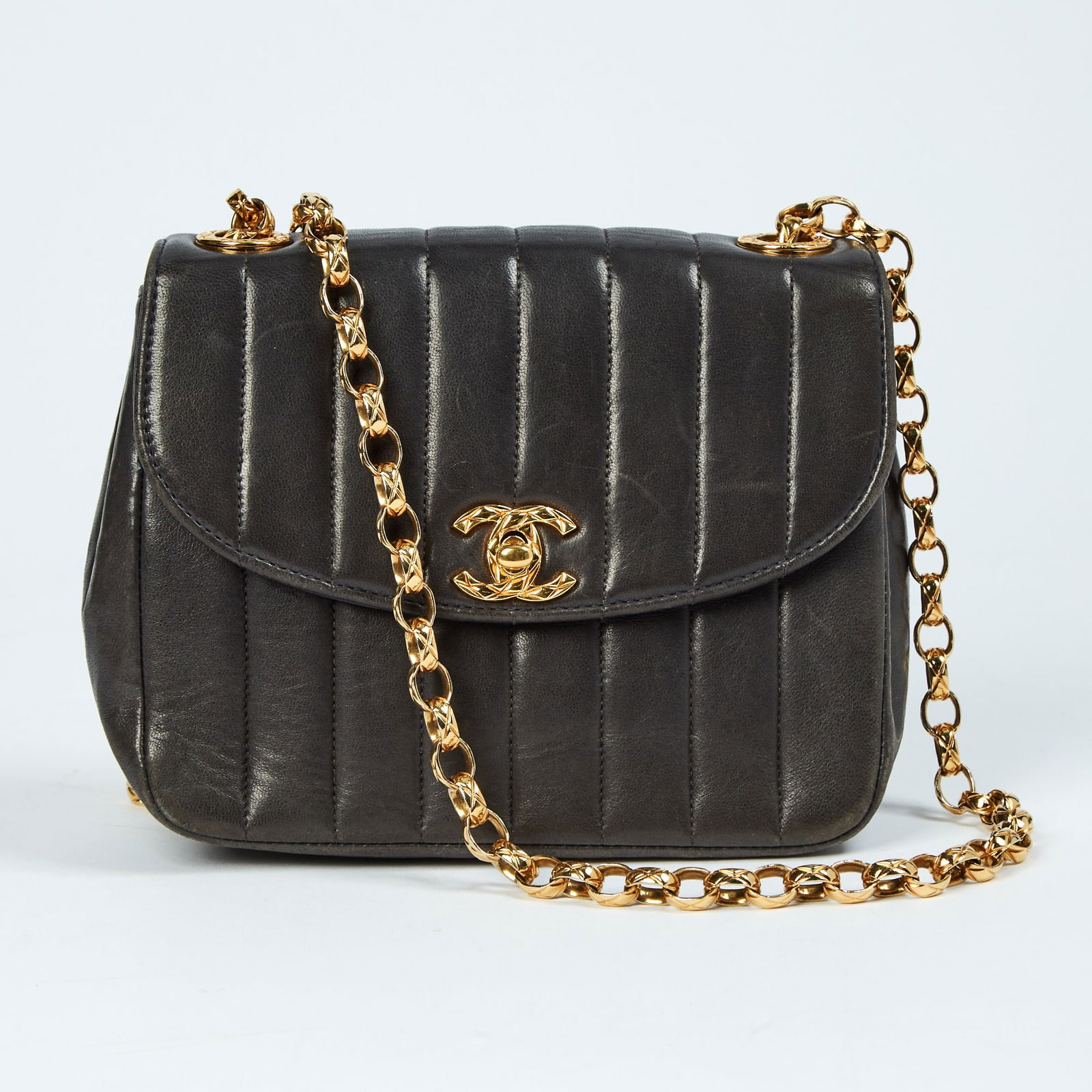 Chanel Black Lambskin Leather Flap Bag: Vertically quilted black leather with gold-tone chain and double 'CC' turn lock closure, mirror under front flap, interior with side zippered and slip pockets, signed Chanel. 7 x 5 1/2 x 2 3/4 inches.