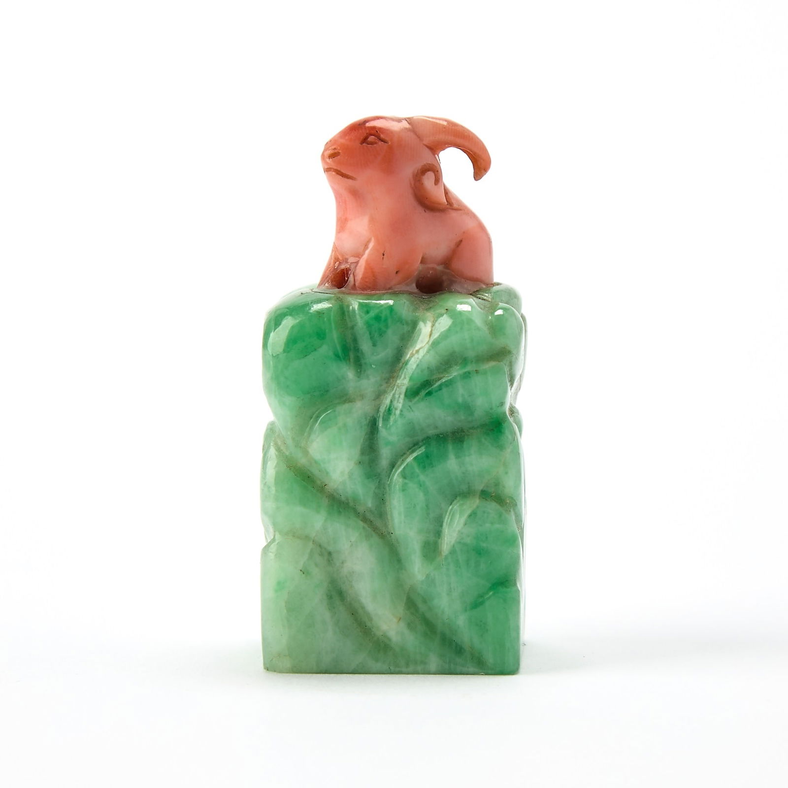 A Chinese Jadeite Snuff Bottle with a Coral Stopper 19th-20th century: Of square, columnar form with carved texture; surmounted by coral figure of a goat. (Height 1 3/4 inches)Qty: (2)