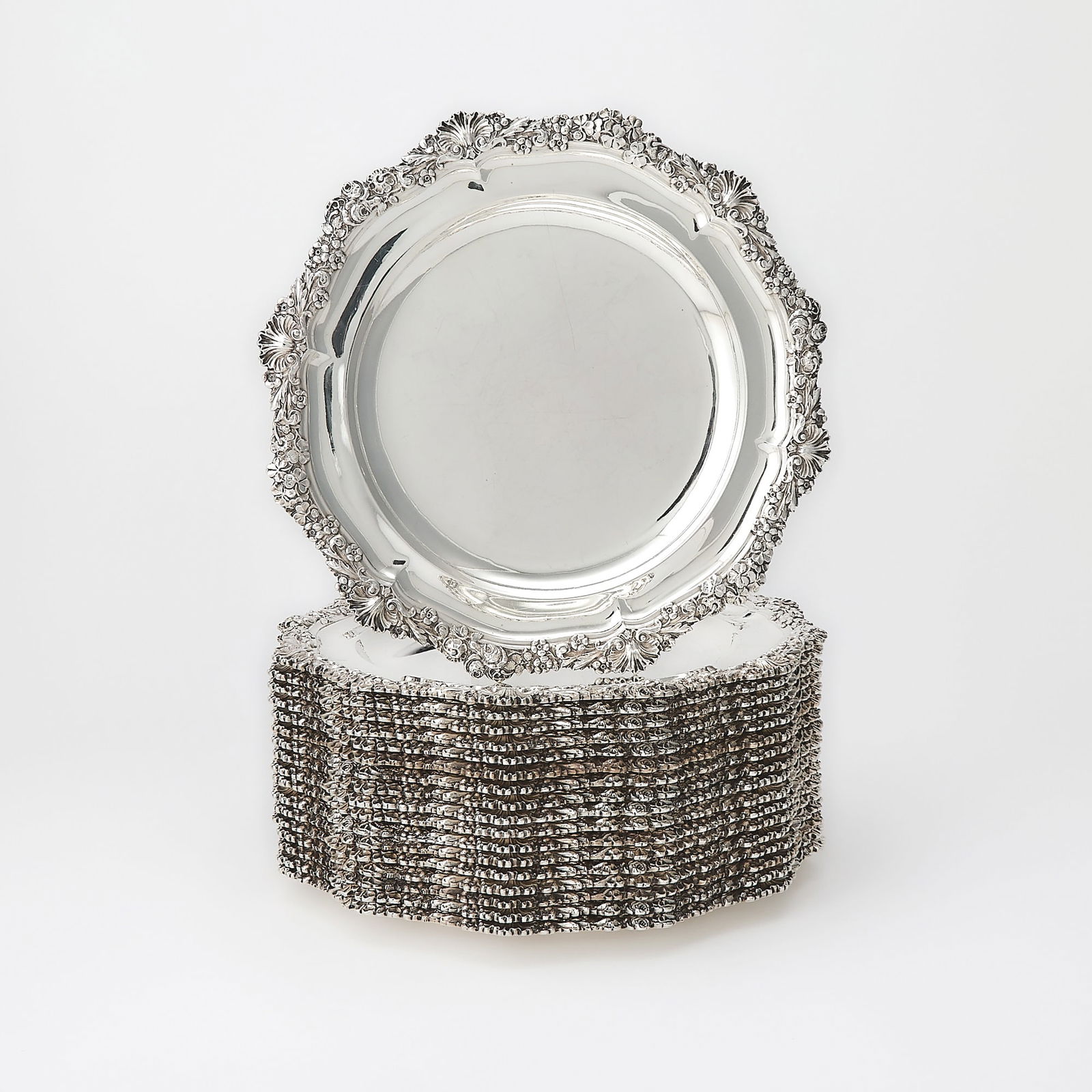 Set of Eighteen Victorian Sterling Silver Dinner Plates: John S. Hunt, London, 1853, also stamped Hunt & RoskelI, Late Storr & Mortimer Circular with shell, rose, shamrock and foliate border. Diameter 10 1/2 inches, total approximately 355 ounces.