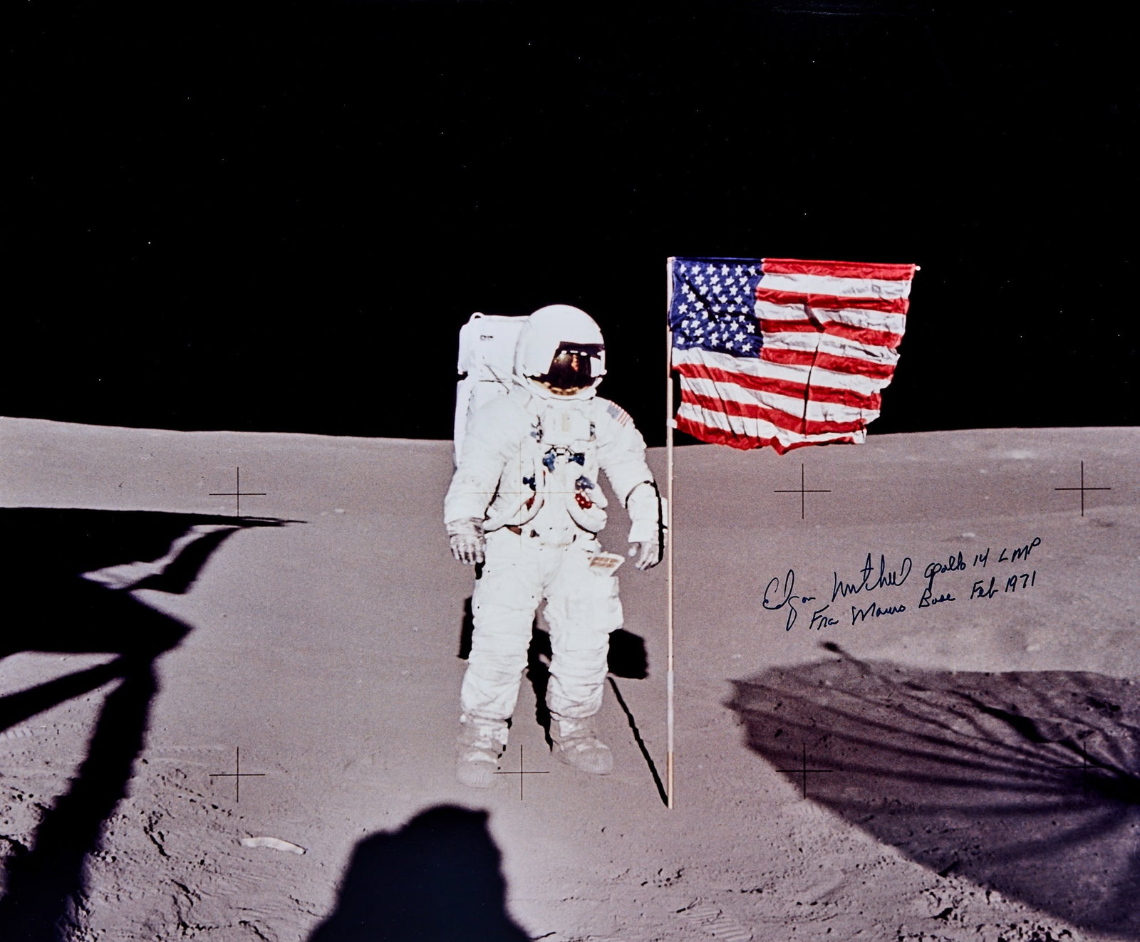 Apollo 14 astronaut Edgar Mitchell on the Moon with the American flag: [SPACE-APOLLO 14] A large colored photograph inscribed by Edgar Mitchell on the Moon with the Ame