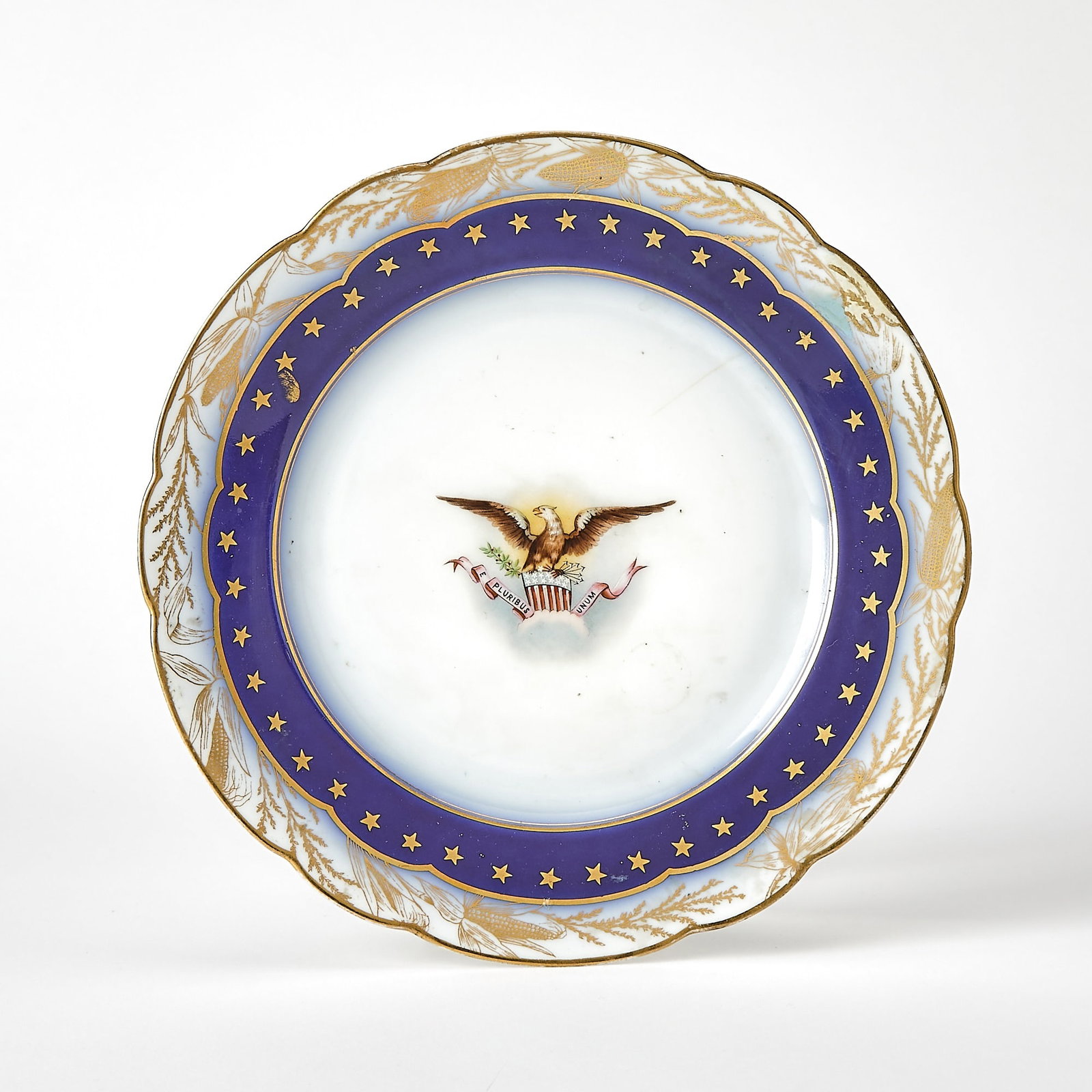 A breakfast plate from the Benjamin Harrison White House service: [HARRISON, BENJAMIN] A breakfast plate from the Benjamin Harrison White House service. A porcelain plate with scalloped edge, the border with a cornstalk design in gilt around a blue band with 44 gold
