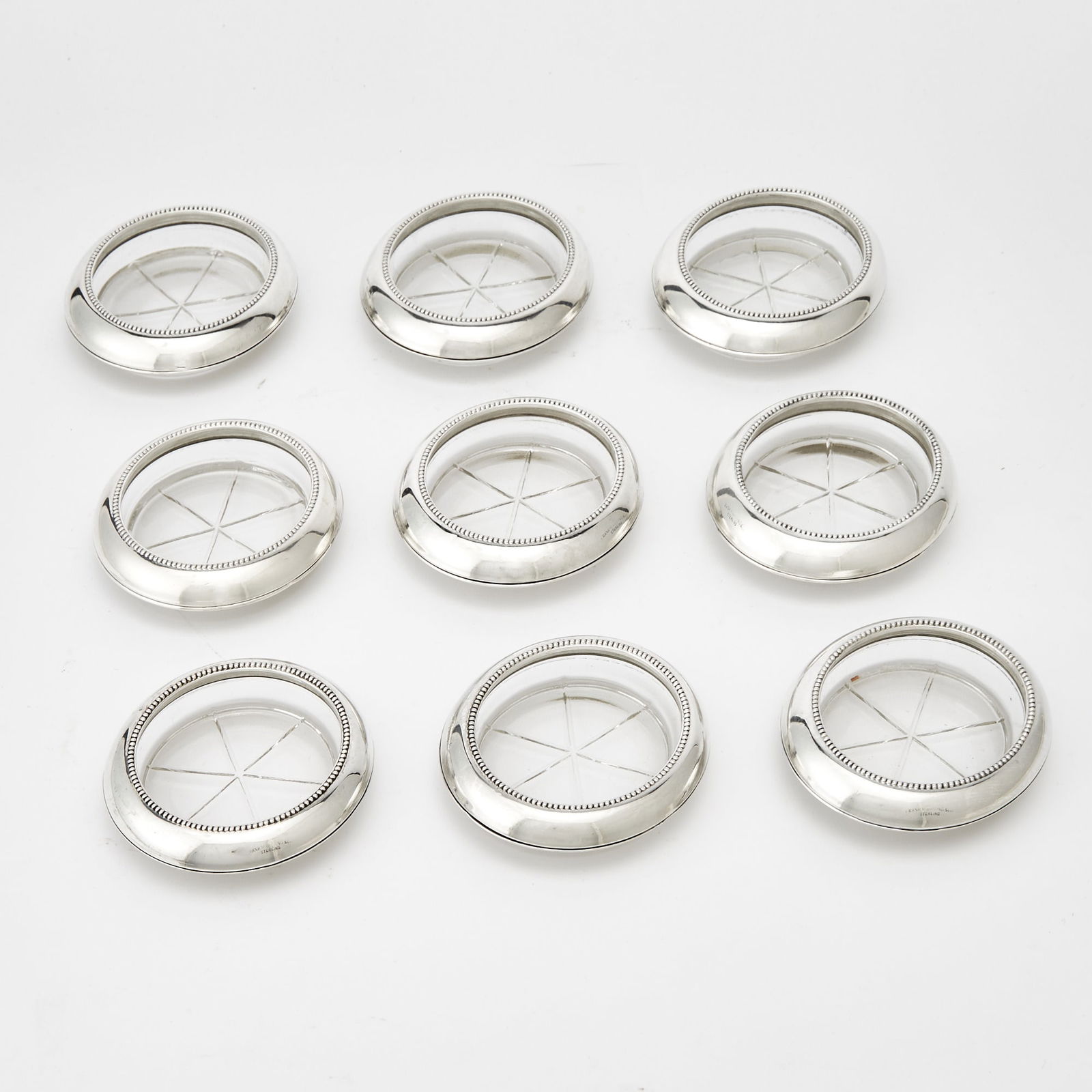 Set of Nine Frank M. Whiting & Co. Sterling Silver and Glass Coasters: Second half 20th century Diameter 3 3/4 inches, weighted.