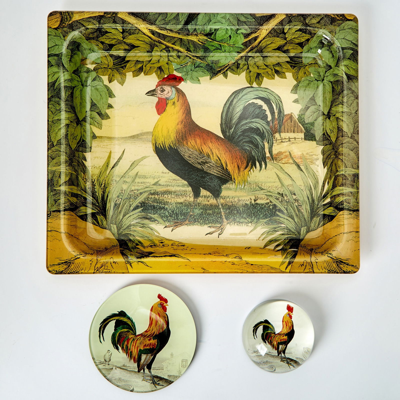 Three John Derian Glass Rooster-Themed Table Articles: Comprising a tray, 15 x 12 5/8 inches; a small dish, diameter 5 1/8 inches; and a paperweight. all in generally good condition