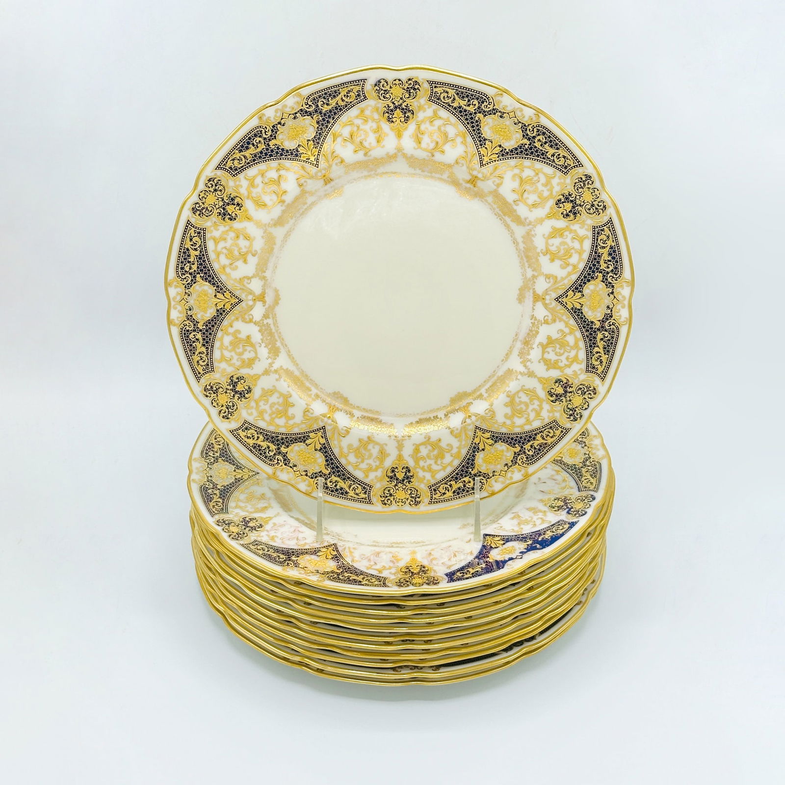 Set of Twelve Lenox Porcelain Dinner Plates: Each with raised gilt border and cobalt spandrels, maker's mark on the reverse. Diameter 10 1/2 inches.These plates bear the mark "J. McD & S. Co." <