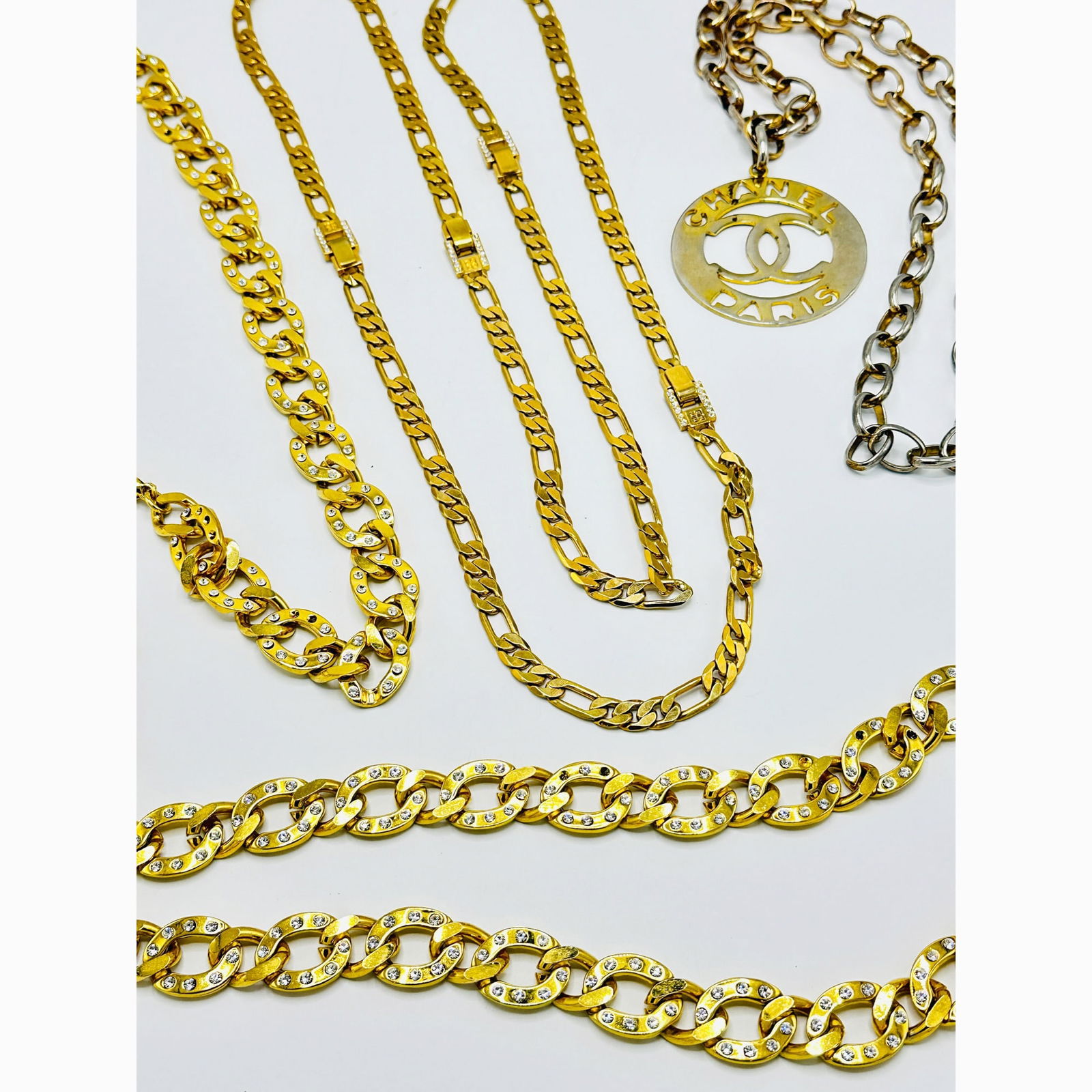 Group of Costume Jewelry: Including a Givenchy figaro necklace that breaks down into four choker necklaces, length overall 63 inches; two rhinestone-studded curblink belts, and a gilt-metal Chanel necklace.