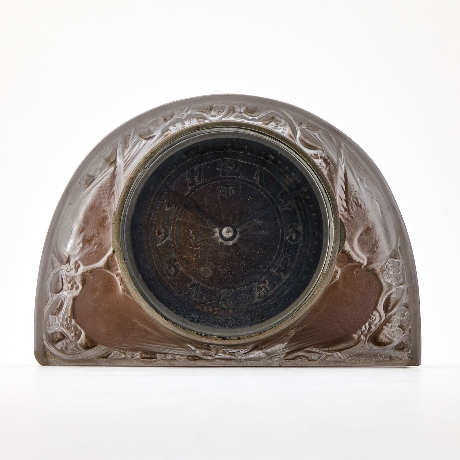 R. Lalique Molded Glass “Moineaux” Mantel Clock: Marcilhac no. 764, designed in 1924 Of flattened domed form, with ATO movement, case engraved R. LALIQUE FRANCE. Height 6 1/8 inches, width 8 5/8 inches, depth 3 inches. Please Note: Doyle does not p