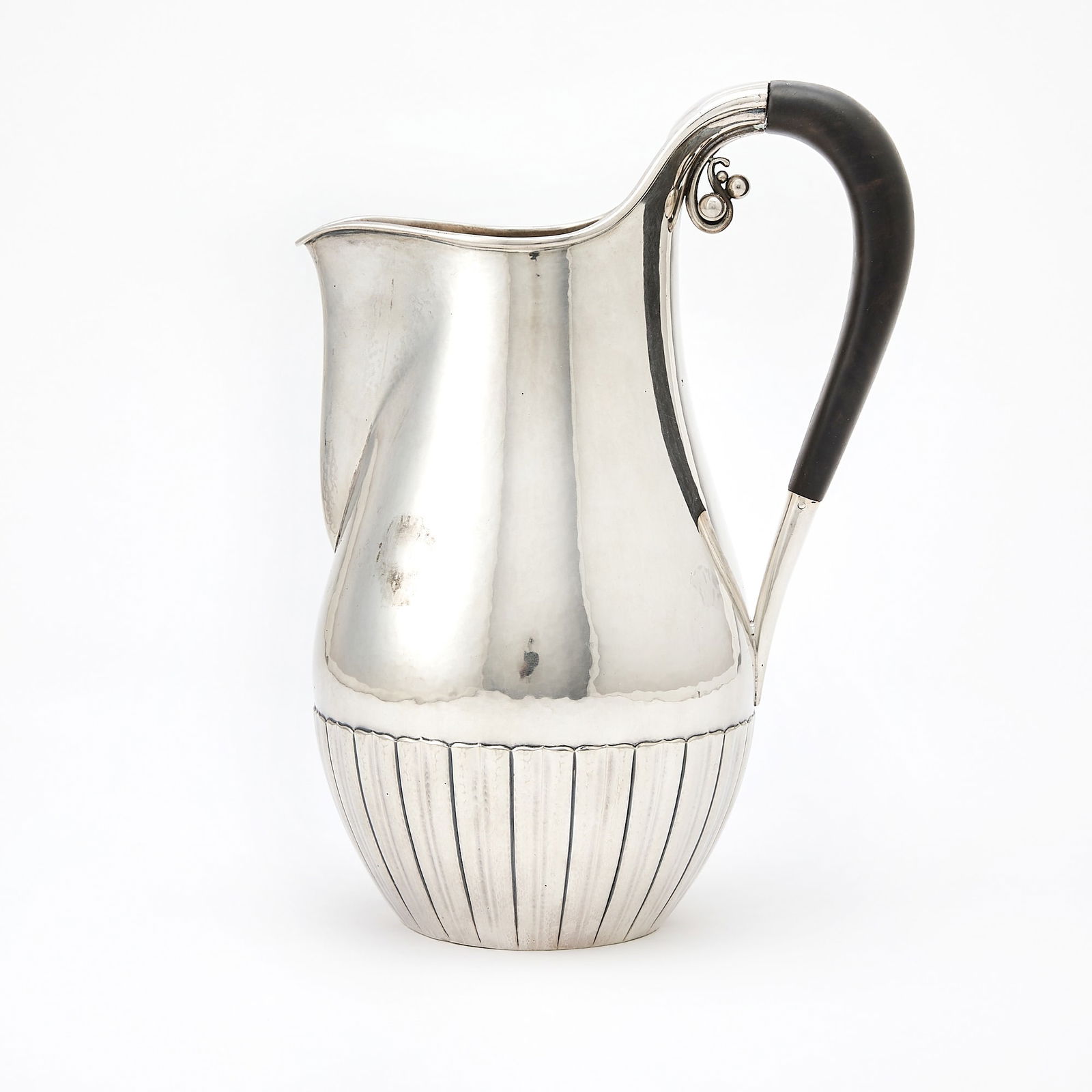 Georg Jensen Sterling Silver Water Pitcher: Design no. 45A, post-1945 Of ovoid form, with a faux ebonized composition handle with a berry cluster terminal, hallmarked. Height 9 1/4 inches, approximately 22 ounces, all in. Appears to be in gene