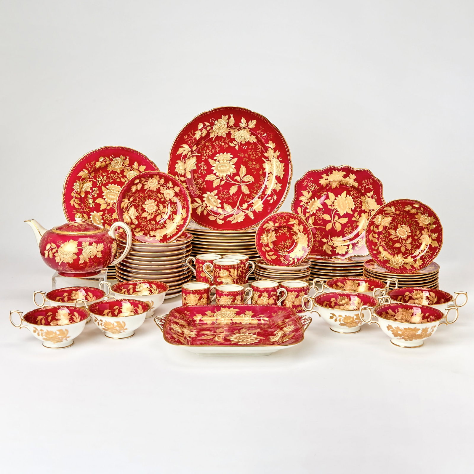 Wedgwood Porcelain “Ruby Tonquin” Pattern Dinner Service: 20th Century Comprising: thirty-five dinner plates, diameter 11 inches; twelve lunch plates, diameter 9 1/4 inches; twelve bread plates; twenty square dessert plates; eleven soup cups and stands; twel