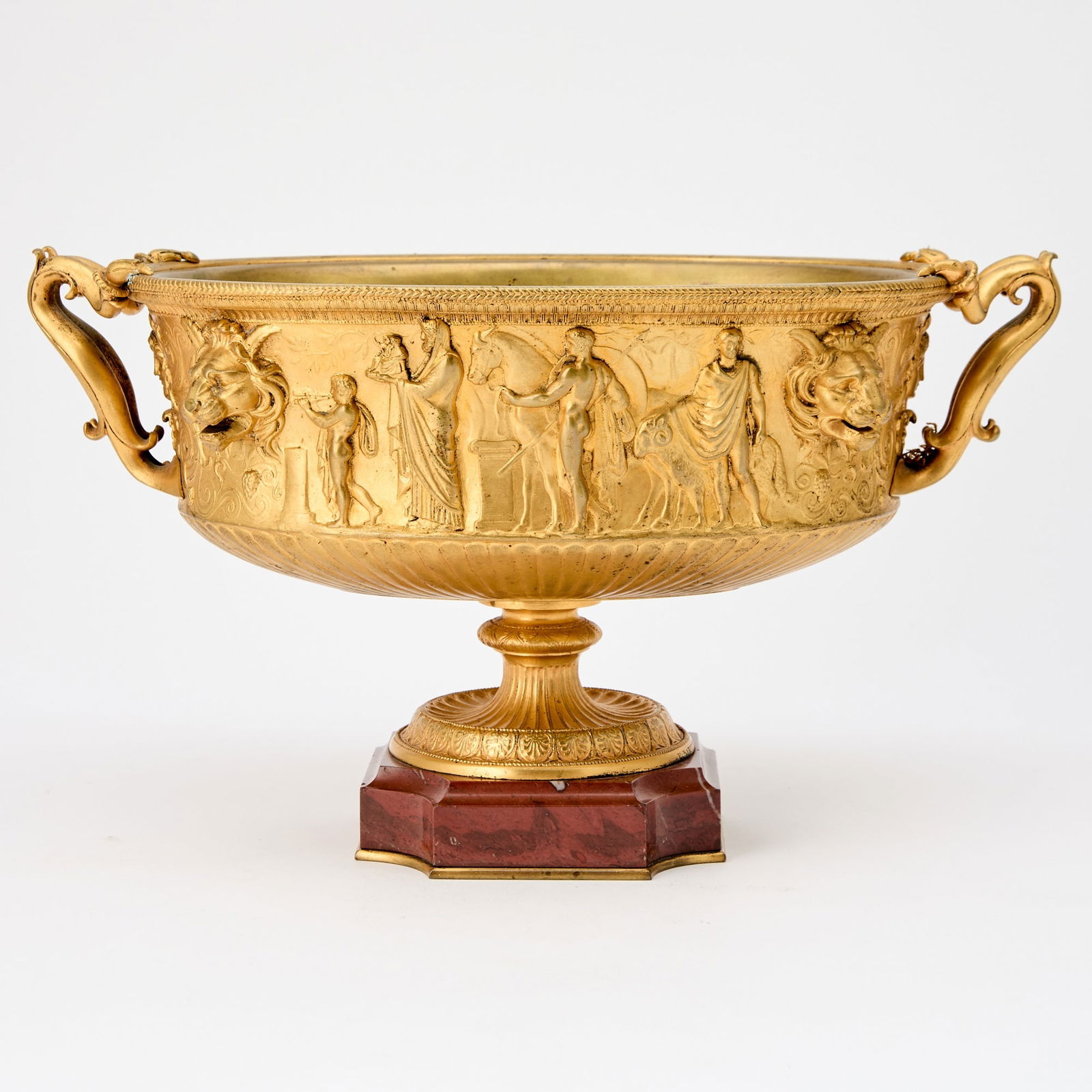 Empire Style Gilt Bronze and Marble Centerpiece: After the model by Ferdinand Barbedienne, 20th century Oval with relief depicting 'suovetaurilia' one of the most sacred traditions and rites of Ancient Rome, flanked by lion masks and two curved hand