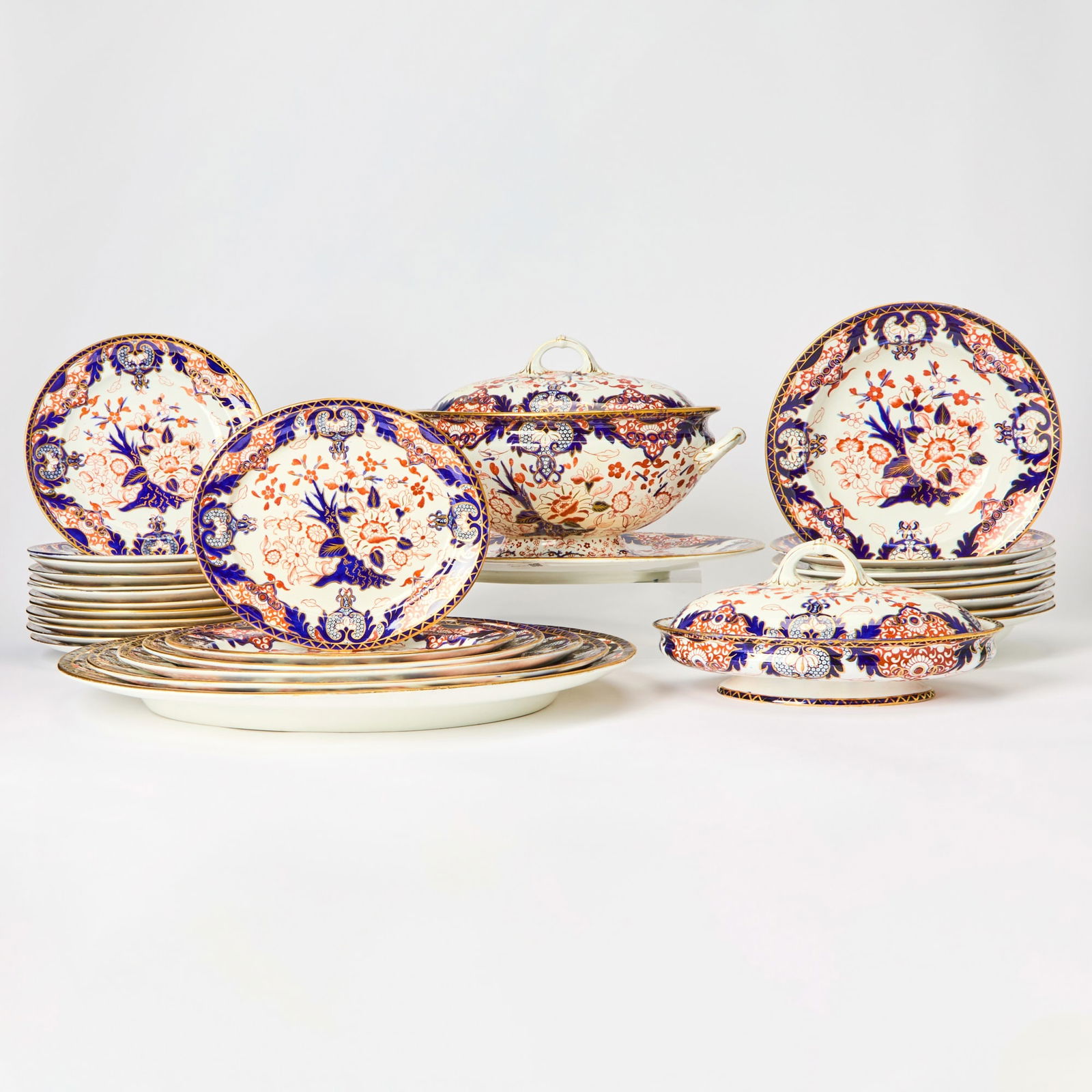 Royal Crown Derby Porcelain "Kings" Pattern Partial Dinner Service: 1878-1914 Each with stylized blossoms in cobalt blue and iron-red, within a C-scroll and foliate border, each with impressed crown and Derby and red maker's marks, comprising twenty lunch plates, diam