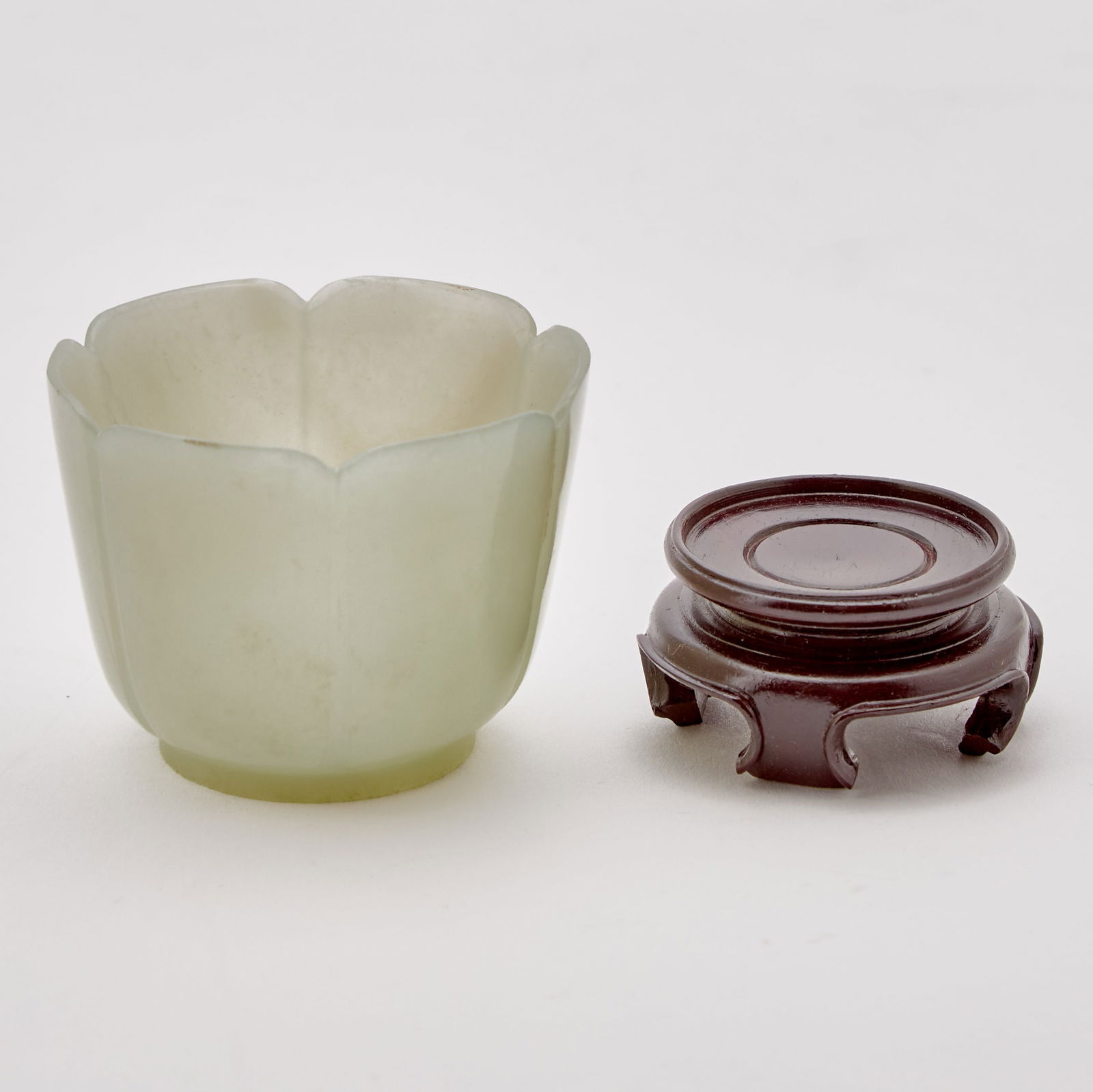 Chinese Carved Celadon Jade Cup 20th Century: The cup with a flaring rim carved with petal-shaped lobes. (Height 1 3/4 inches)