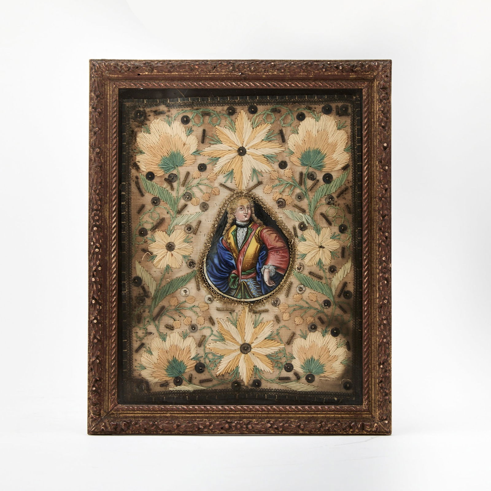 Louis XV Framed Needlework and Enamel Plaque: Mid-18th century The central tear-drop-shaped enamel plaque features the portrait of Louis XV in bright enamels, set within a floral silk-embroidered cotton surround with applied gilt and metal beads.