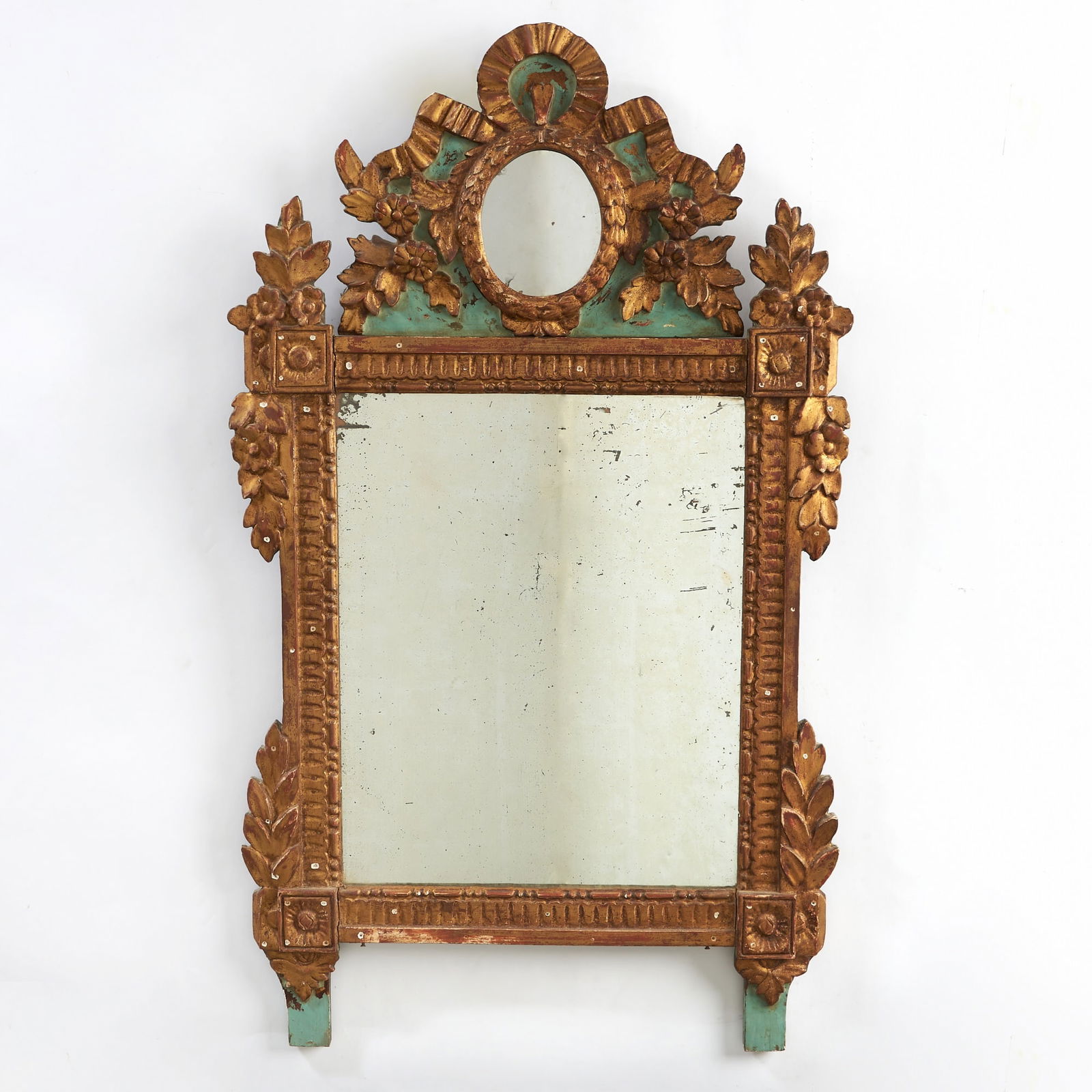 Louis XVI Parcel-Gilt and Painted Wood Mirror: Probably Piedmontese, last quarter 18th century The rectangular mirror plate within an acanthus and foliate-clasped carved surround surmounted by a ribbon and foliate carved cresting centered by a sma
