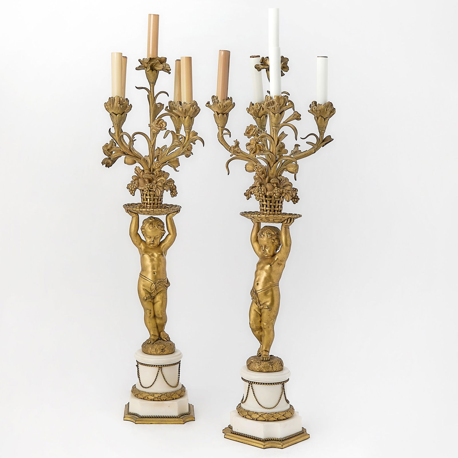 Pair of Louis XVI Style Gilt-Bronze and White Marble Figural Five-Light Candelabra: Late 19th Century Height 28 3/4 inches (73 cm). Fitted for electricty, Doyle does not quarantee electric wiring to be in working condition.
