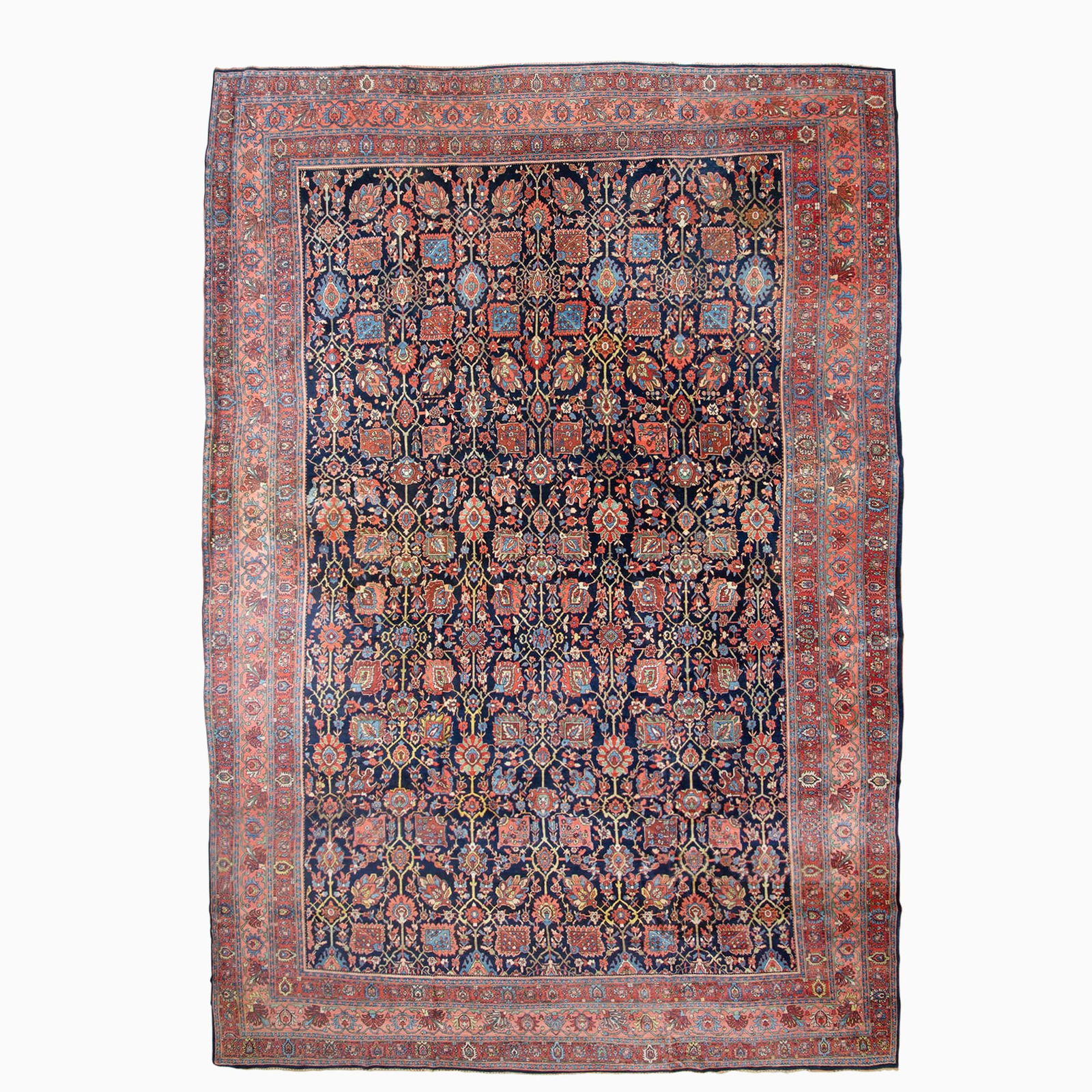 Bidjar Carpet: North Persia, Early 20th century The overall pattern of polychrome floral vinery on the midnight blue field is within a coral palmette and vine border. Cotton foundation. 19 feet 0 inches x 12 feet 11