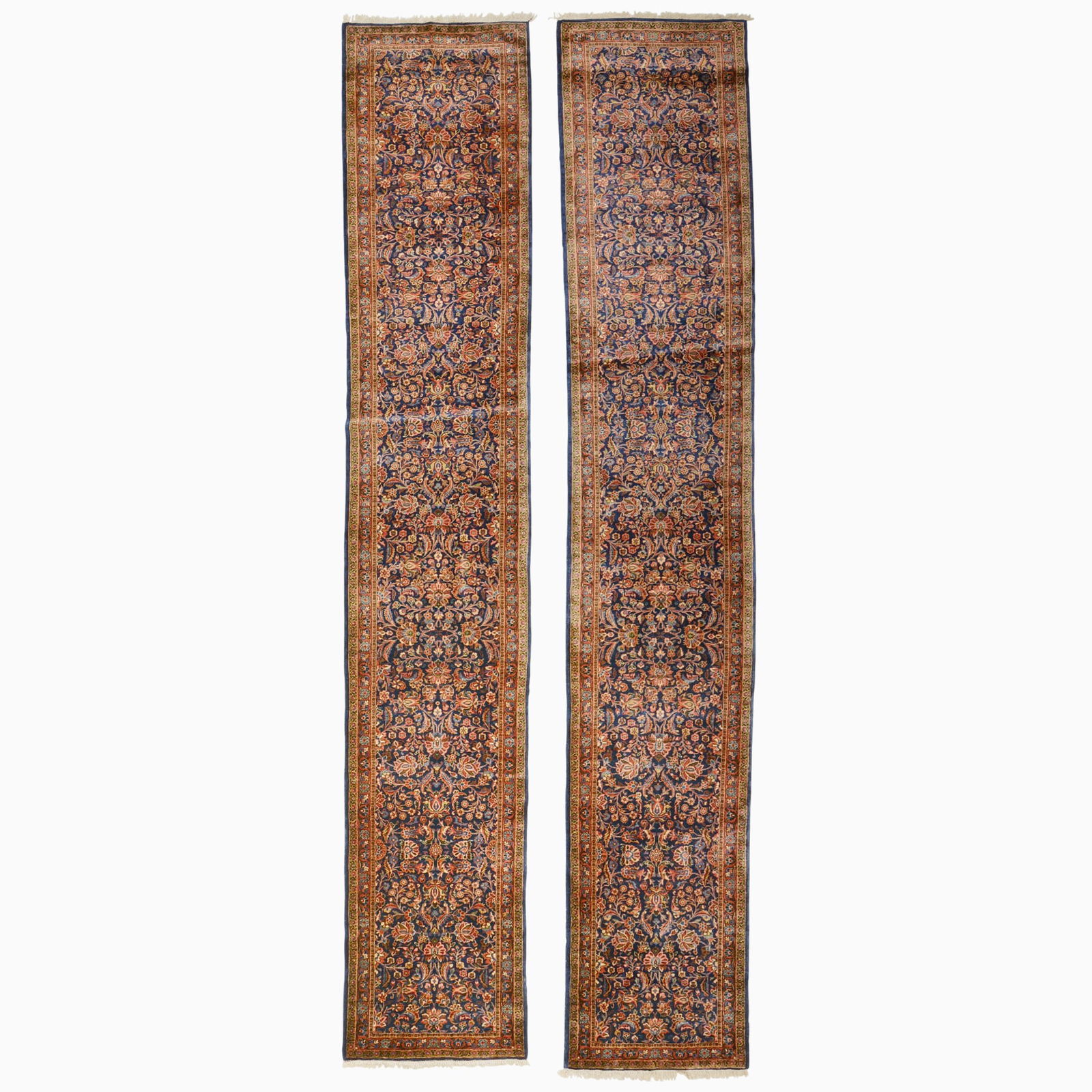 Pair Of Kashan Runners: Central Iran, 2nd 1/4 20th Century Each with polychrome floral patterns overall on indigo fields within madder borders. 12 feet 10 inches x 2 feet 4 inches and 12 feet 9 inches x 2 feet 4 inches.