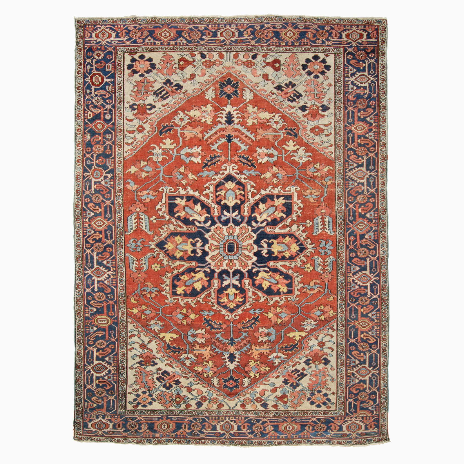 Heriz Carpet: Northwest Persia, Late 19th Century The central geometric pendant medallion on the madder field flanked by ivory spandrels is within an indigo palmette and vine border. 12 feet 10 inches x 9 feet 3 in