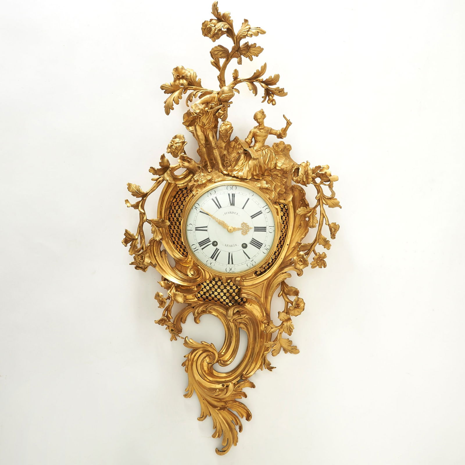Large and Rare Louis XV Gilt-Bronze Cartel Clock: By Hardel a Paris, circa 1755 Of asymmetrical design, modelled with scrolling acanthus, foliate sprays, and playful figures above the circular enamel dial with Roman numerals and outer Arabic quarter-