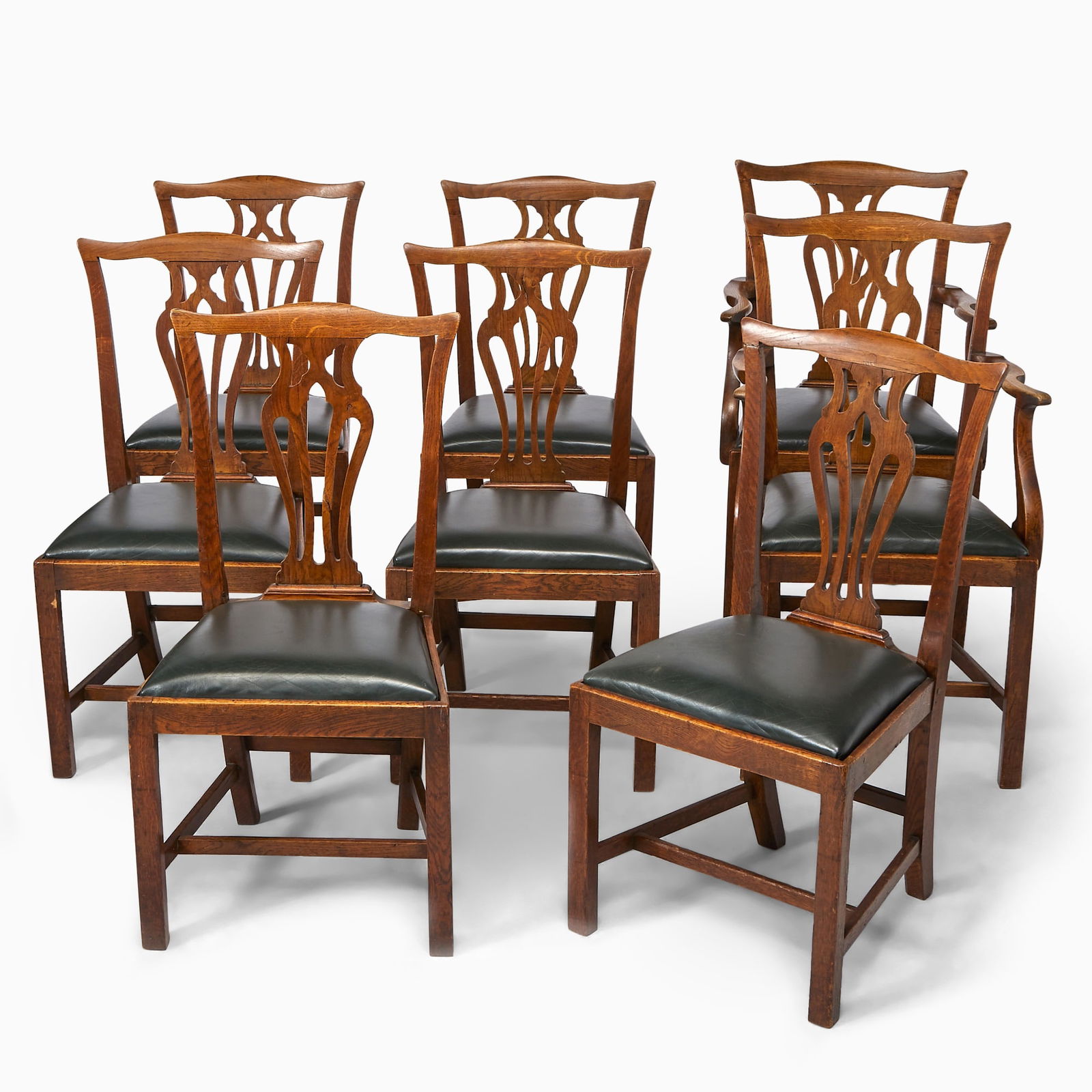 Set of Eight George III Provincial Oak Dining Chairs: Early 19th centuryComprising two armchairs and six side chairs, each serpentine crestrail above a pierced vasiform splat, S-curve arms and supports, and drop-in seat, on chamfer legs joined by
