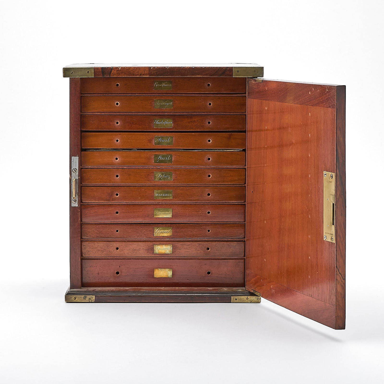Victorian Figured Walnut Jewelry Cabinet by J.Bramah, London (124 Piccadilly): Circa 1885The rectangular cabinet veneered throughout in finely figured and cross-banded walnut, opening to reveal a fitted interior of multiple graduated drawers, each engraved with brass labels