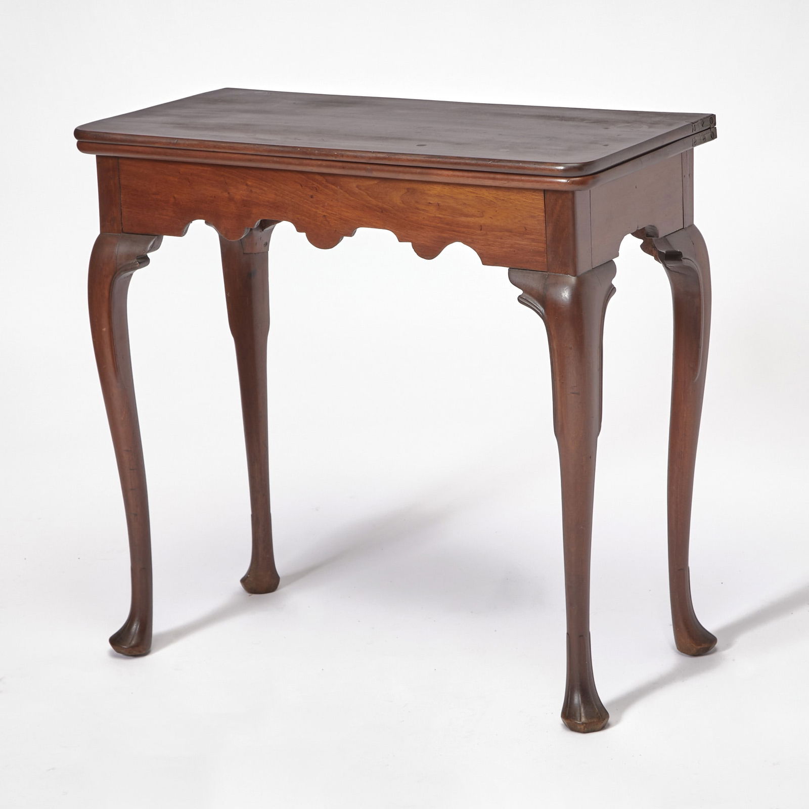 Irish George II Style Mahogany Fold-Over Table: 19th/20th centuryThe hinged rectangular top with rounded corners above a scalloped apron, on cabriole legs ending and faceted pad feet. Height 29 3/4 inches (75.6 cm), width 30 inches (76.2 cm), depth