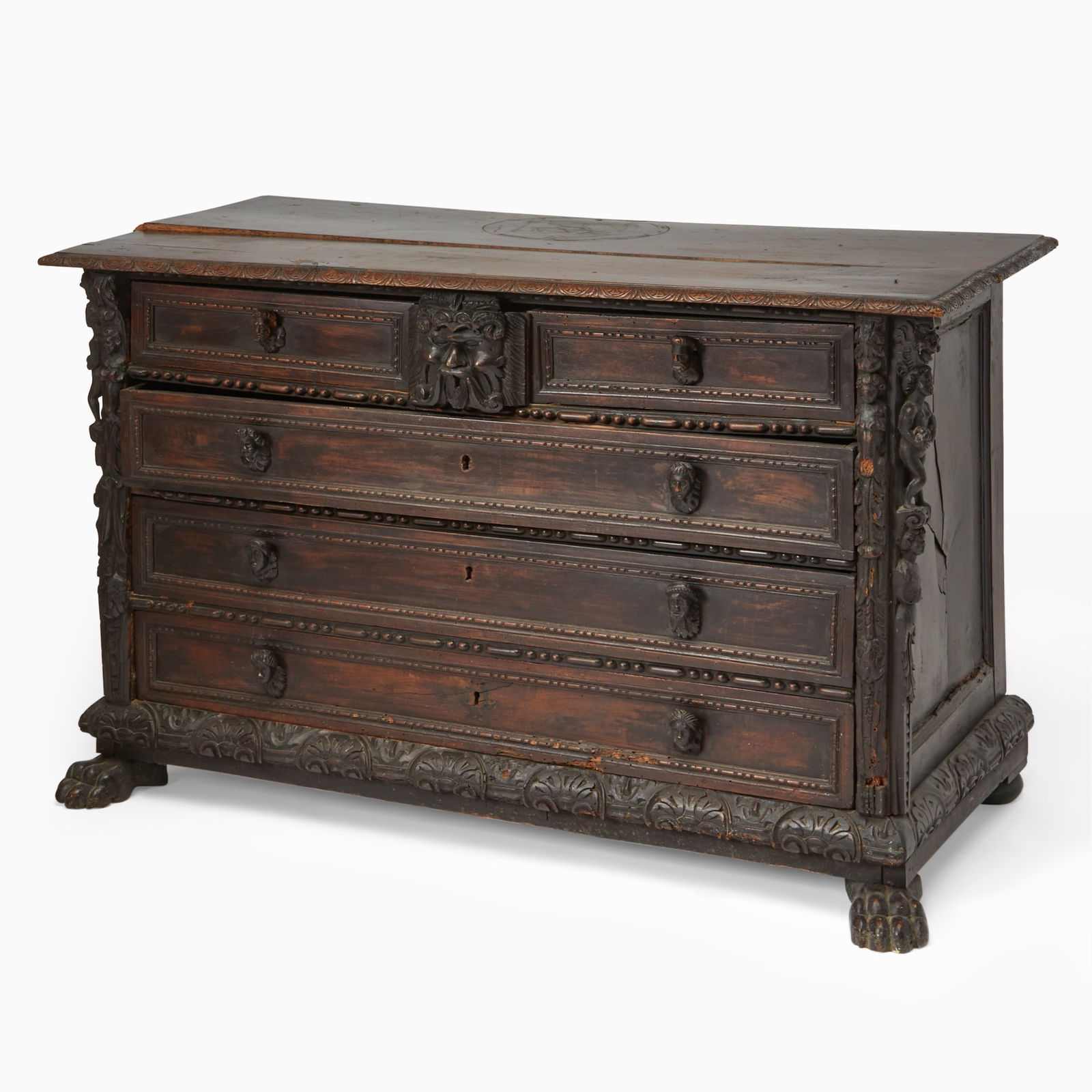 North Italian or Tuscan Renaissance Carved Walnut Cassettone (Commode): Late 16th century/early 17th Century The rectangulatr molded top above a boldly case fitted with two short drawers over three long drawers, each drawer front carved with framed panels and with mask pu