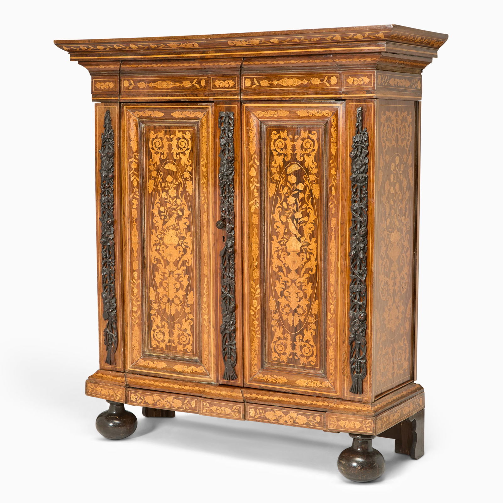 Dutch Baroque Fruitwood Marquetry Ebonized and Rosewood Two-Door Cabinet: Third quarter 17th Century The rectangular moulded cornice above a pair of panelled door, each inlaid with elaborate scrolling foliate arabesques and floral reserves, within multiple crossbanded and l