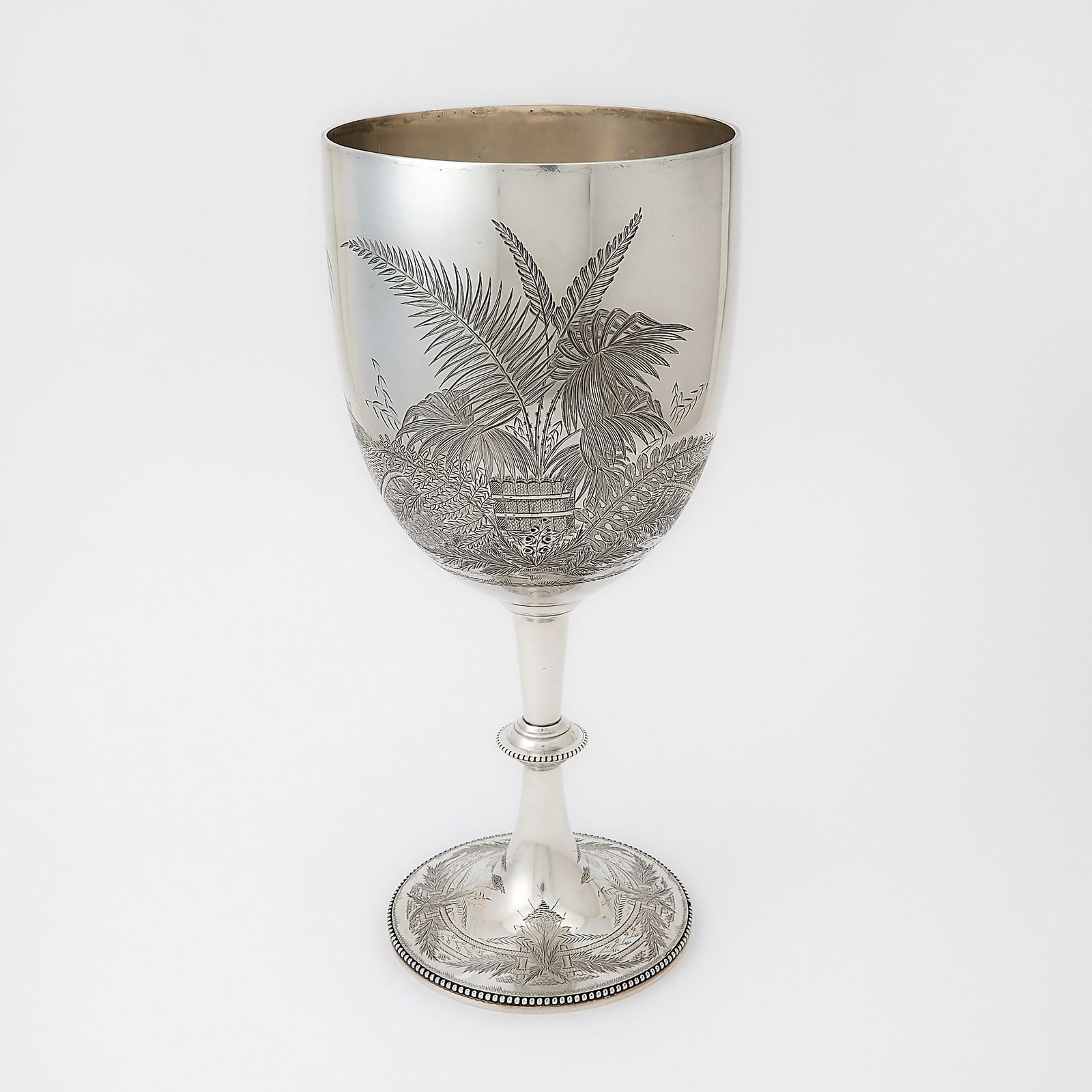 Victorian Sterling Silver Oversized Goblet: Charles Stuart Harris, London, 1875 The bowl and base engraved with palms and ferns, the knopped stem and foot with beaded rims. Height 15 1/4 inches (38.5 cm), approximately 40 ounces. Generally