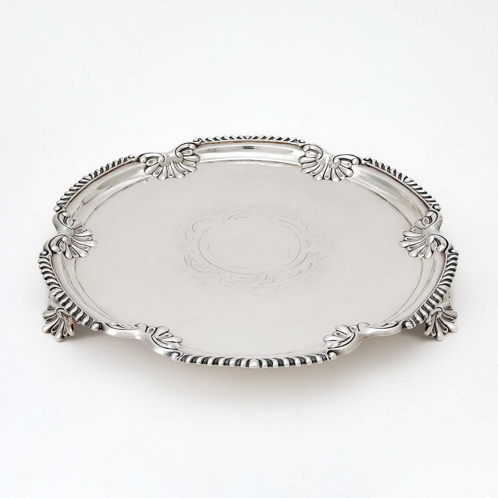 Victorian Sterling Silver Salver: London, 1901 Shaped circular with shell and gadroon border, raised on three shell feet. Diameter 15 inches (38 cm), approximately 52 ounces. The center with soft erasure; surface marking from normal