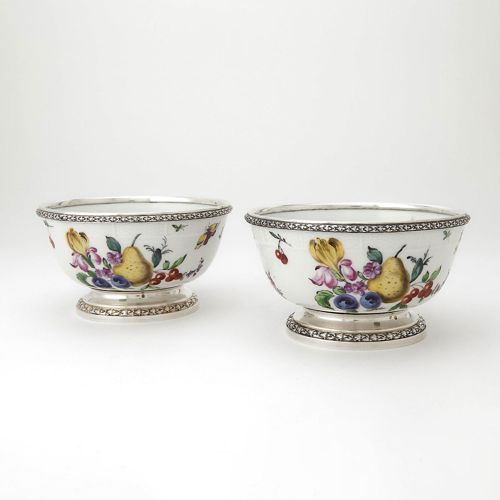 Pair of French Silver Mounted Samson Porcelain Bowls: Mounts marked Tetard Freres, Paris, 19th Century; the porcelain with crossed lines in underglaze. Each circular decorated with flowers, fruits, vegetables and butterflies. Height 3 3/4 inches, (9.5 cm