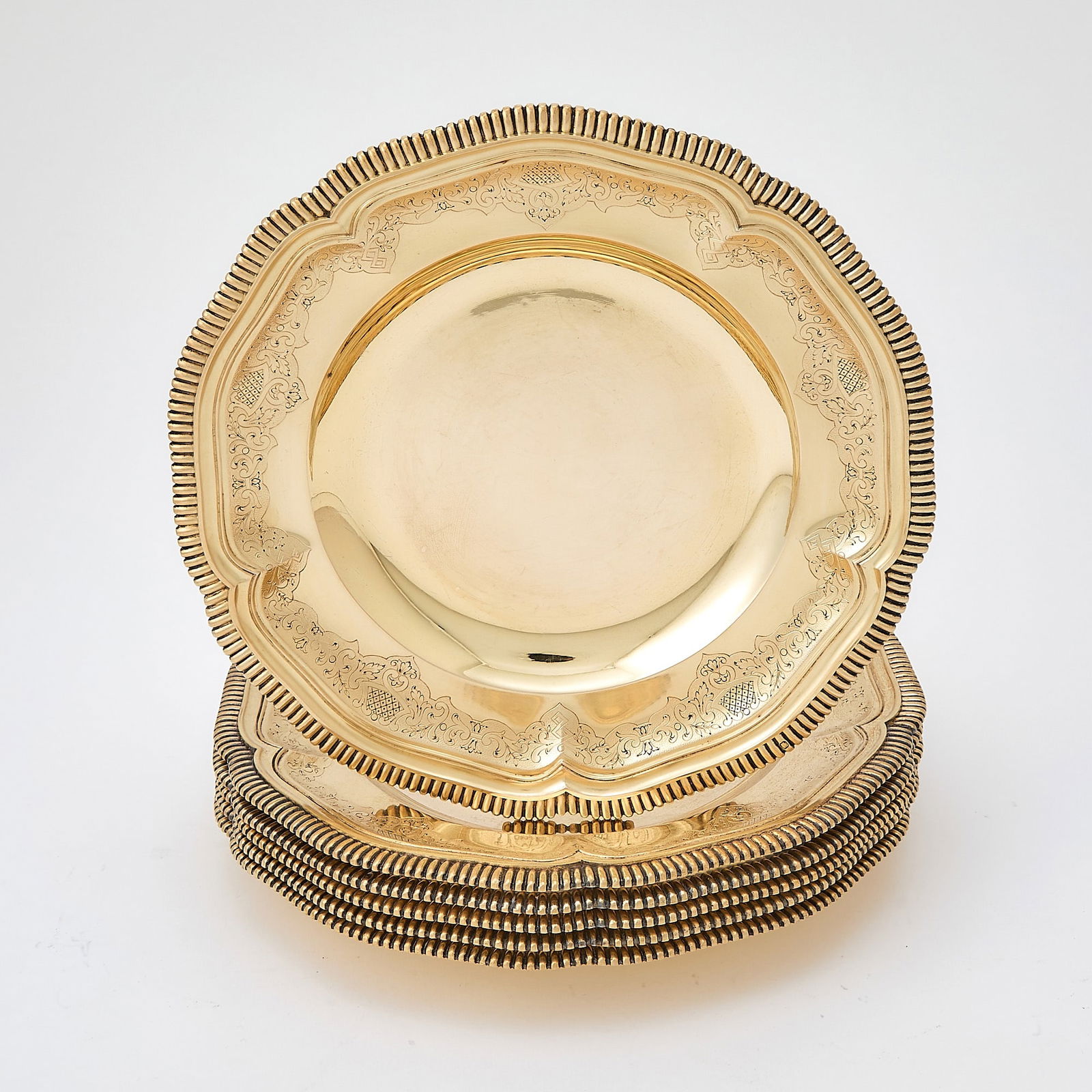 Set of Six French Silver Gilt Footed Plates: Bointaburet, Paris, late 19th/early 20th century Each shaped circular with engraved border and reeded rim, raised on three feet. Diameter 8 3/4 inches (22.5 cm), total approximately 80 ounces. 