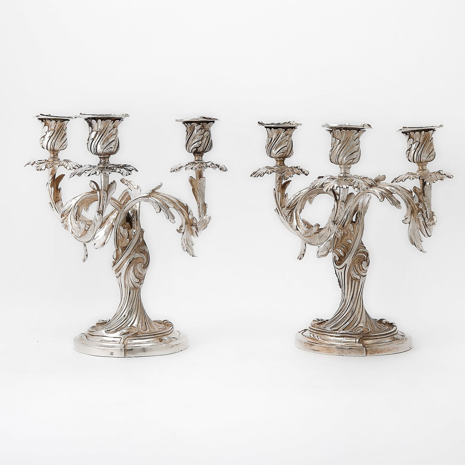 Pair of French Silver Three-Light Candelabra: 20th Century In the Louis XV style, the spiral fluted stems issuing three foliate scroll branches. Height 9 1/2 inches (24 cm), diameter 8 1/2 inches (21.5 cm), total approximately 139 ounces. 