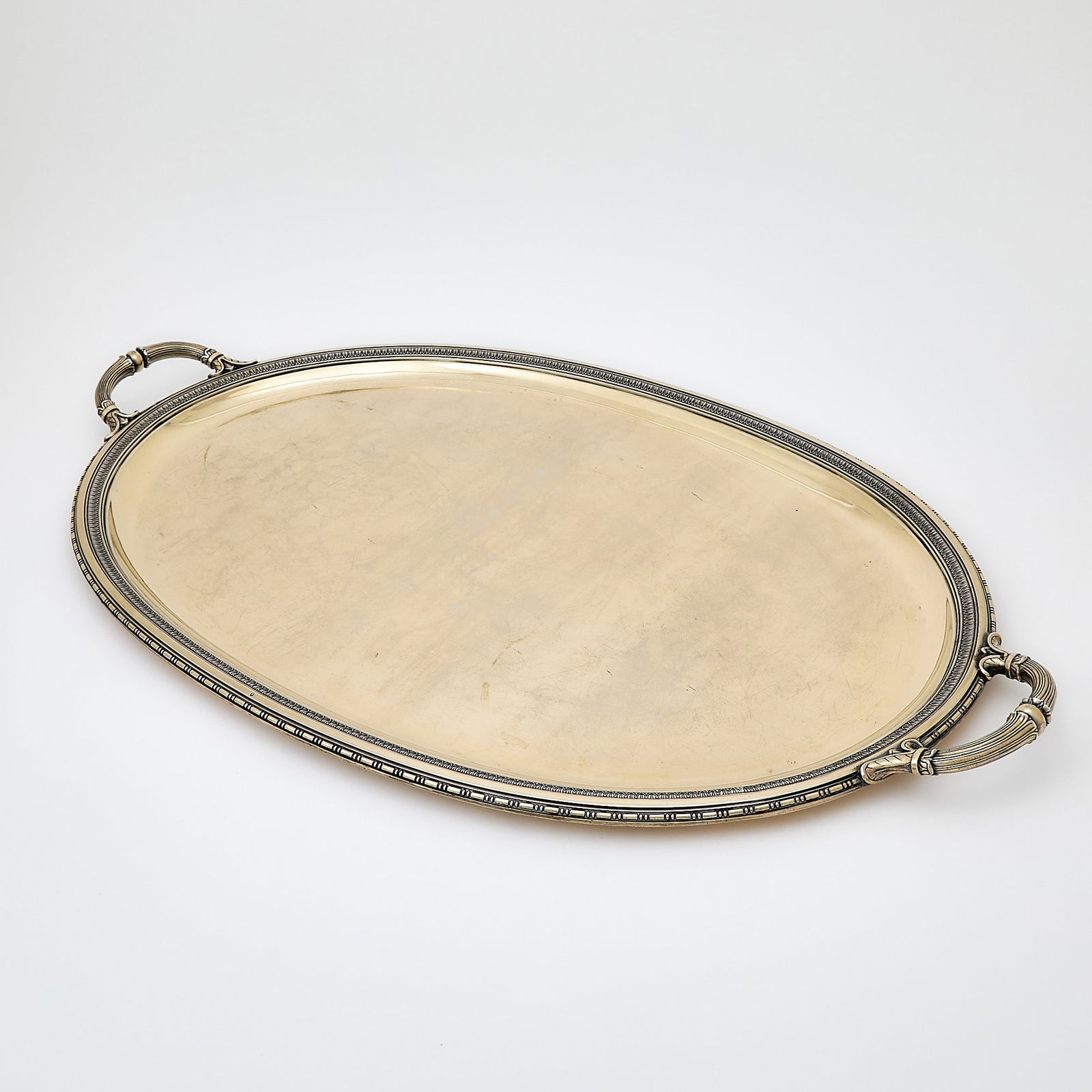 French Silver Gilt Two Handled Tray: First half 20th century Oval with leaf-tip and beaded borders, the reeded handles with foliate joins. Length over handles 31 inches (79 cm), approximately 179 ounces. Generally good condition