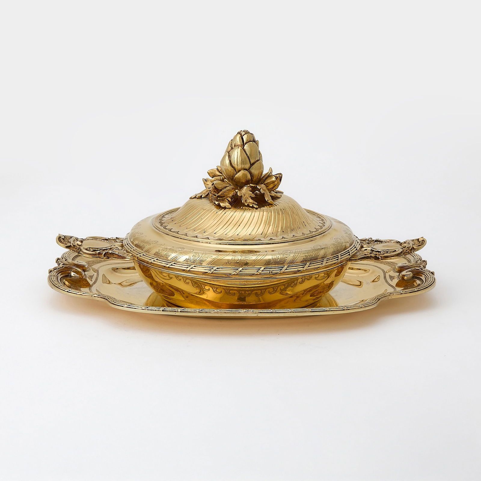 Puiforcat Silver Gilt Covered Ecuelle and Tray: 20th Century In the Louis XVI style, the ecuelle with cast flat handles, the cover with part spiral fluting, with artichoke form finial; the tray shaped rectangular with tied reeded border. Length of