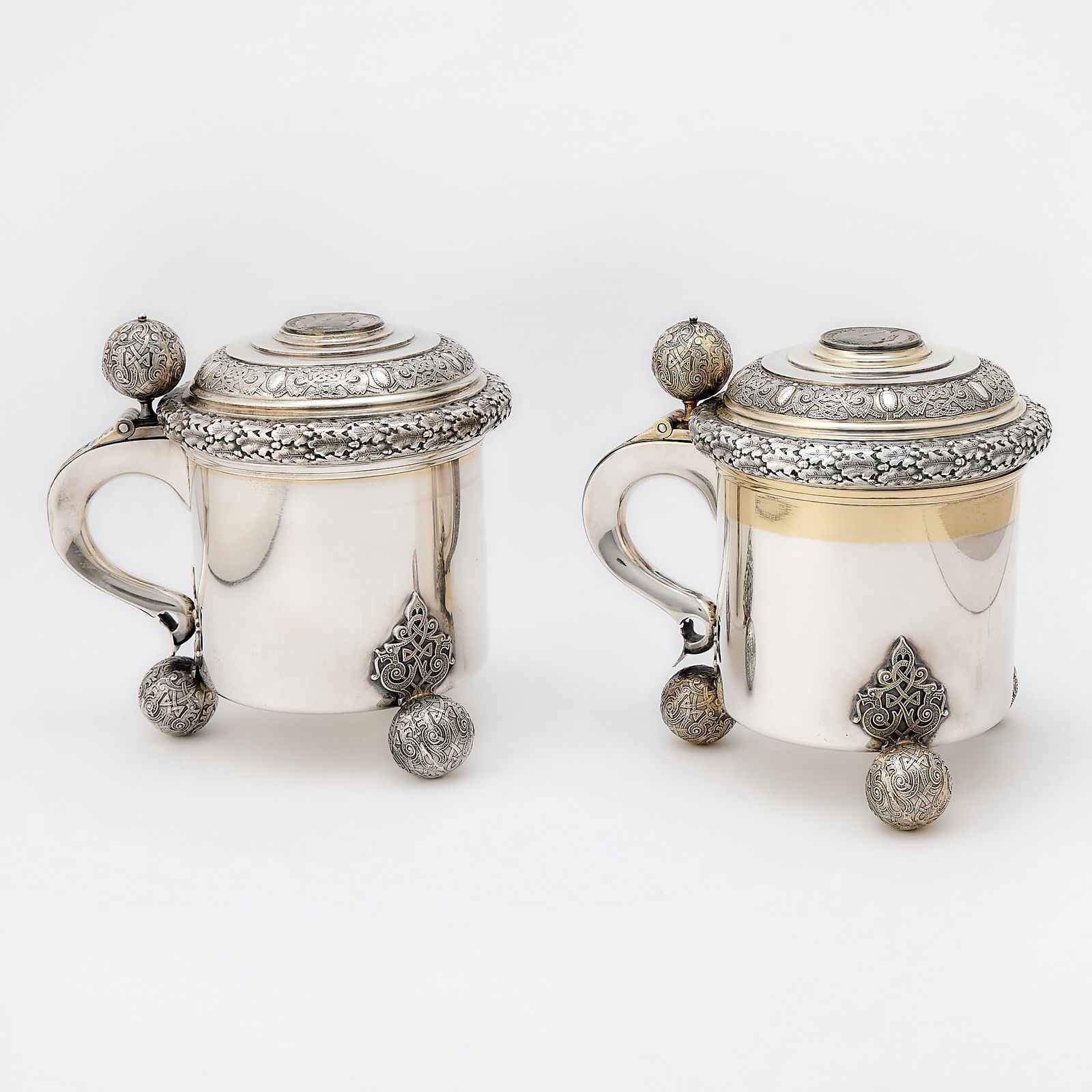 Pair of Swedish Silver Covered Tankards: Guldsmedsaktiebolaget, Stockholm, 1932/1939 Each cylindrical, the hinged cover wtih band of oak leaves and portrait medallion of King Gustaf V, with ball thumbpiece and scroll handle, all raised on th